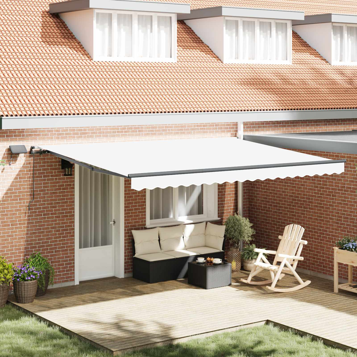 Eine weiße Markise fährt über eine Terrasse mit Korbmöbeln, einem Schaukelstuhl und Pflanzen aus.