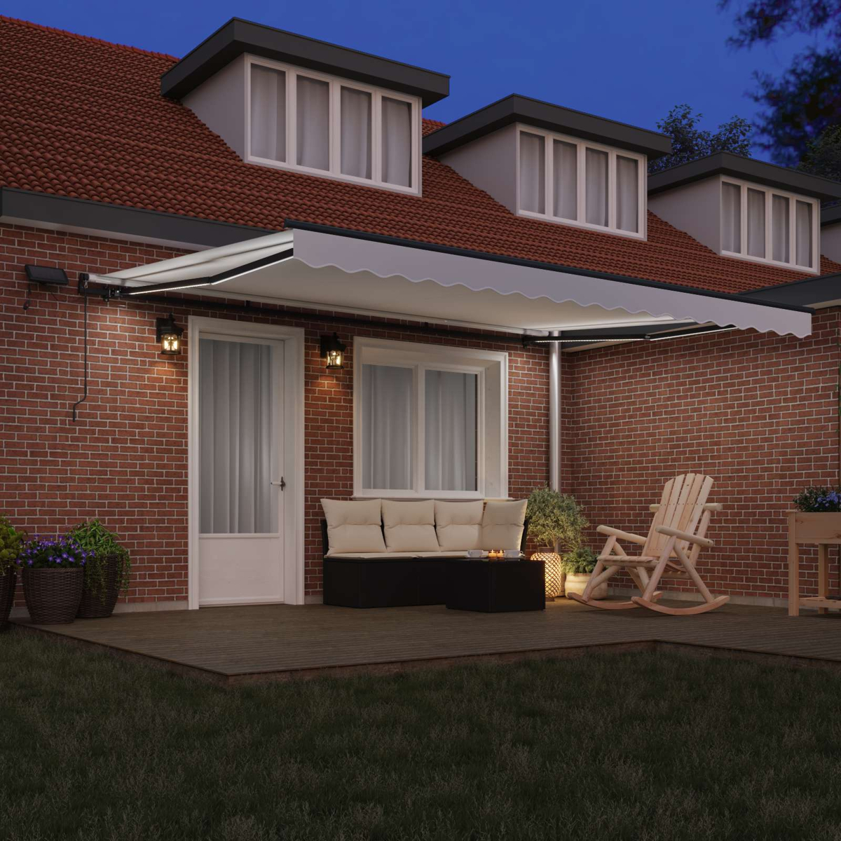 Eine Terrasse mit Móbeln und Markise bei Nacht, Ziegelhaus im Hintergrund.