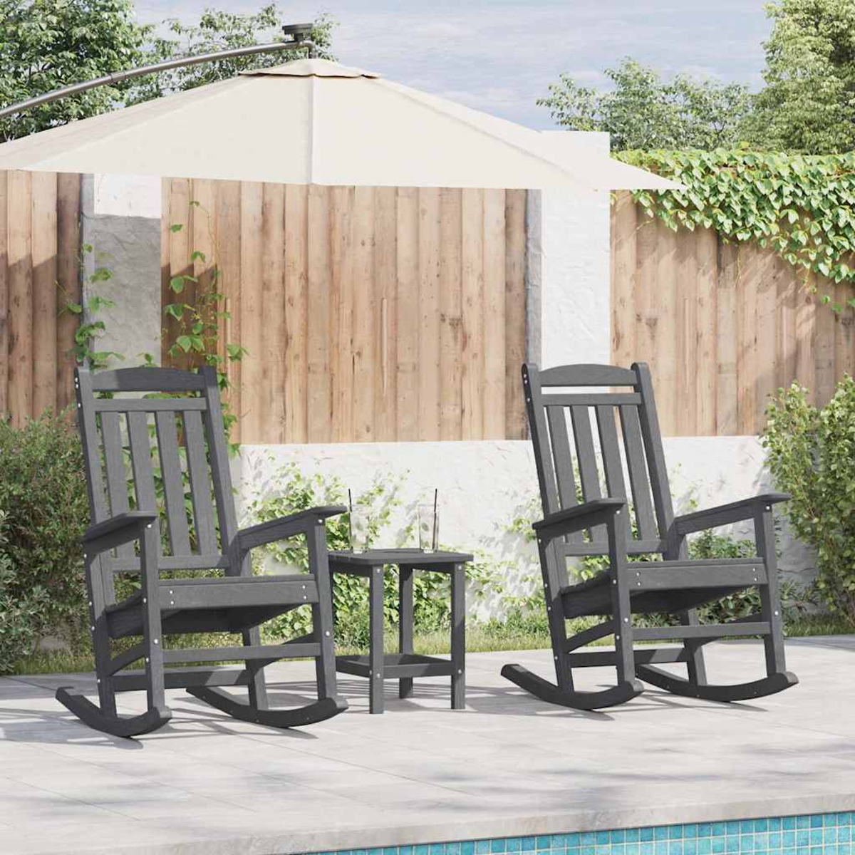 Zwei dunkle Schaukelstühle und ein Tisch stehen auf einer Terrasse neben einem Pool.