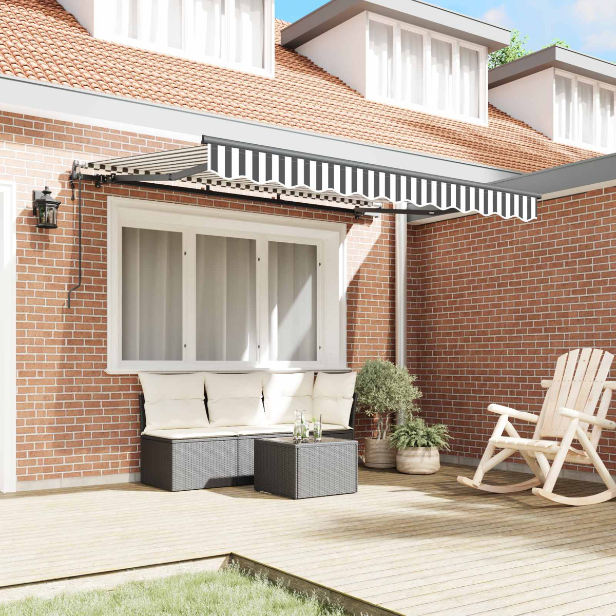 Eine überdachte Terrasse mit Sofa, Tisch, Schaukelstuhl und Pflanzen.