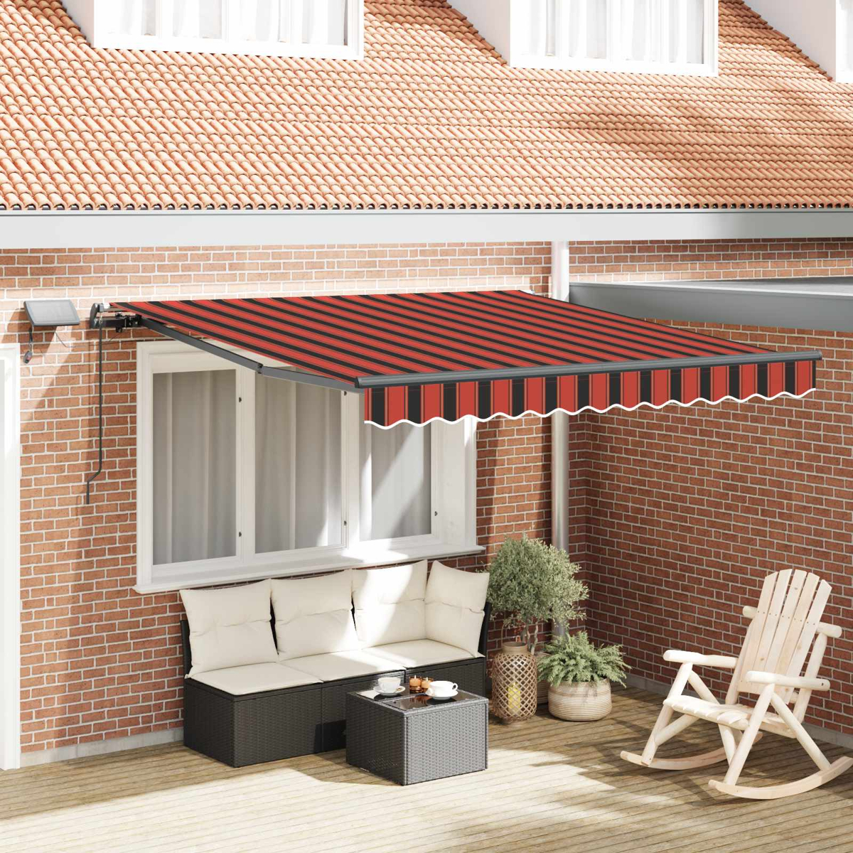 Ausgestattete Terrasse mit Markise, Sofa, Couchtisch, Schaukelstuhl und Pflanzen.