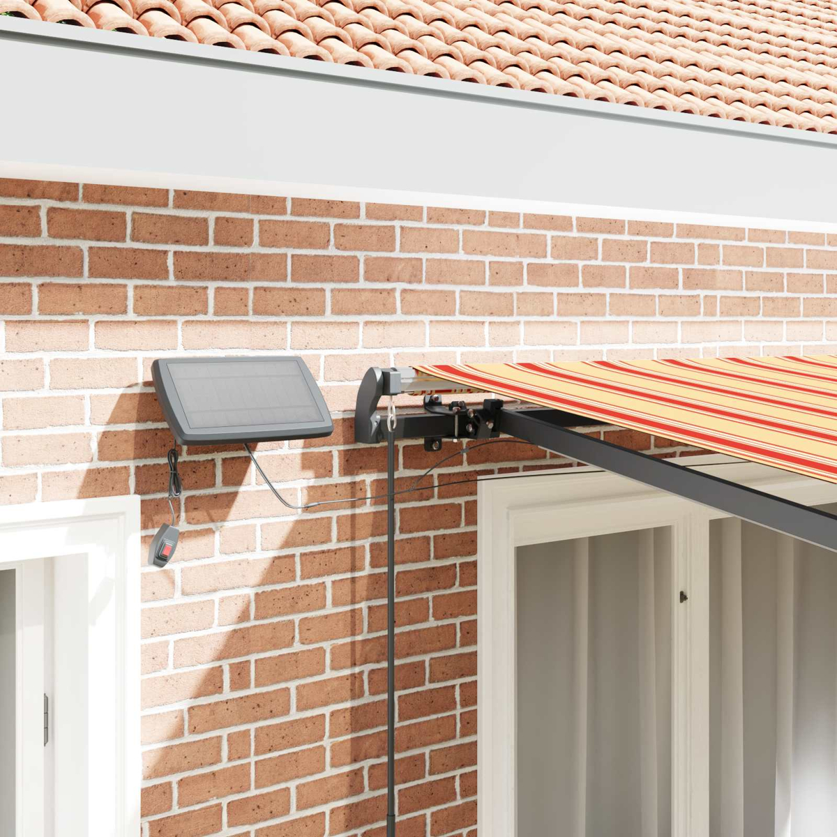 Ein Solarpanel und Markisenarm an einer Ziegelwand mit gestreifter Markise.