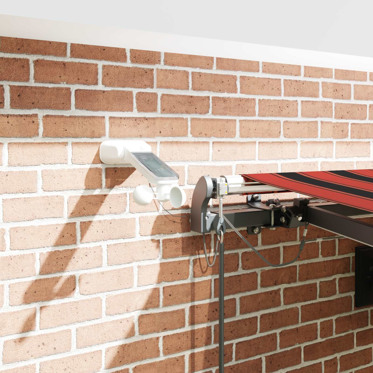 Un dispositivo meteorológico blanco con panel solar en pared de ladrillo, junto a toldo.