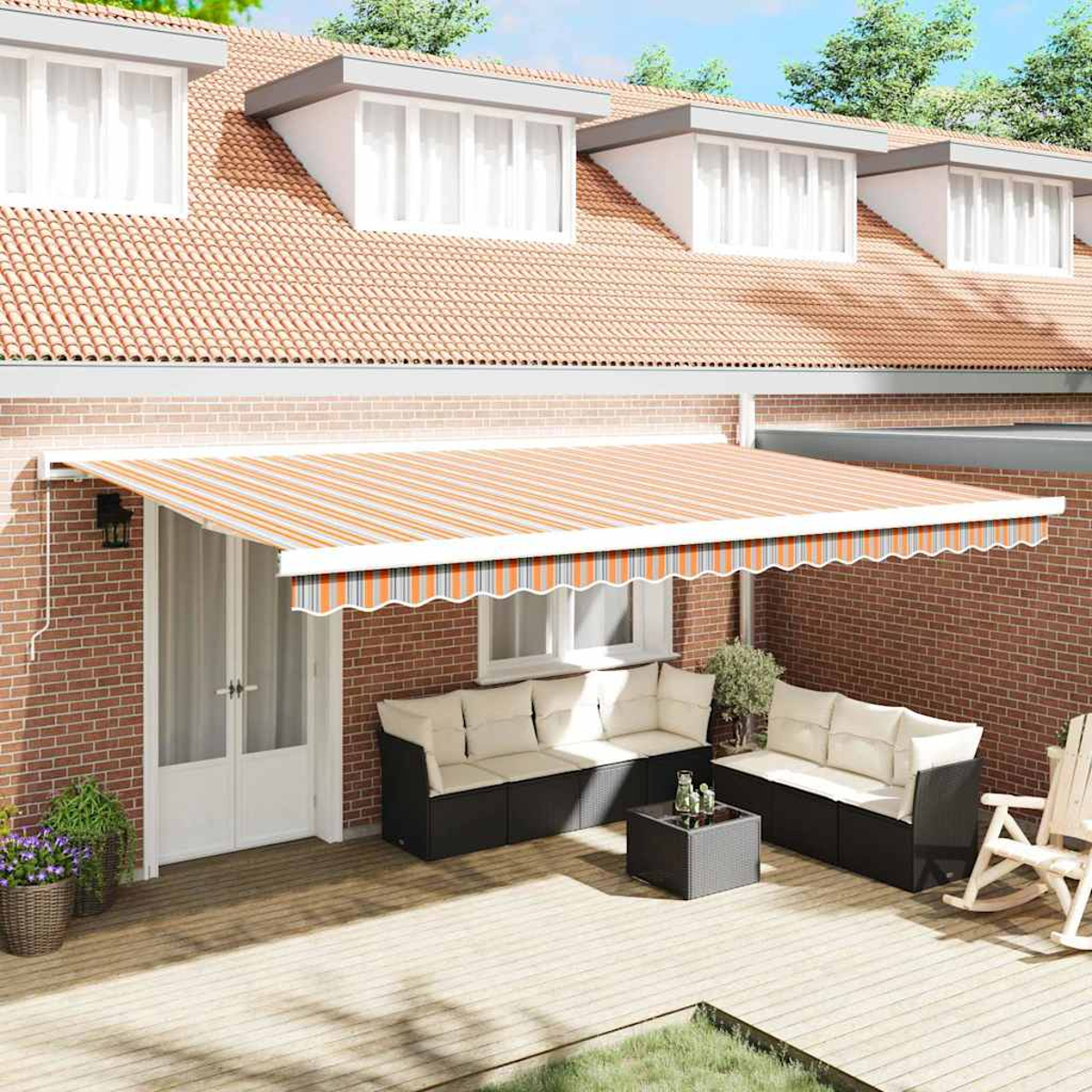 Ein gestreifter Markise bedeckt eine Terrasse mit Korbmöbeln und Schaukelstuhl.