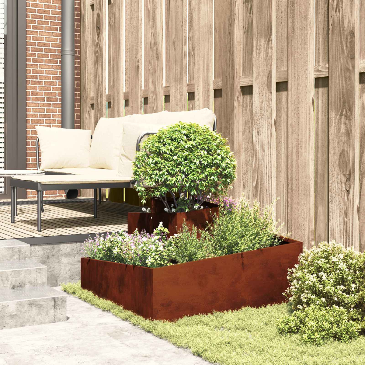 Moderne Terrasse mit gestuften rostigen Pflanzgefäßen, grünen Pflanzen, Sofa und Holzzaun.