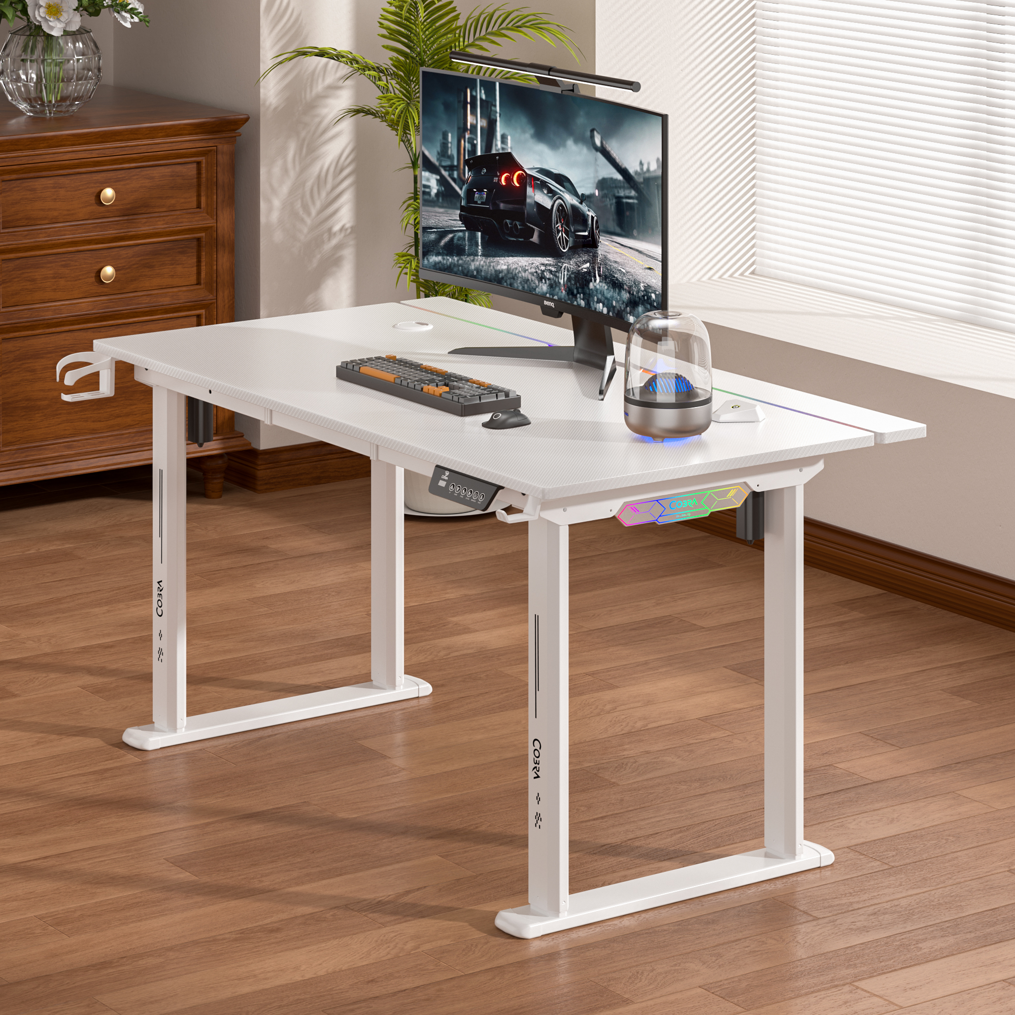 Białe biurko z monitorem, klawiaturą, myszą i głośnikiem.