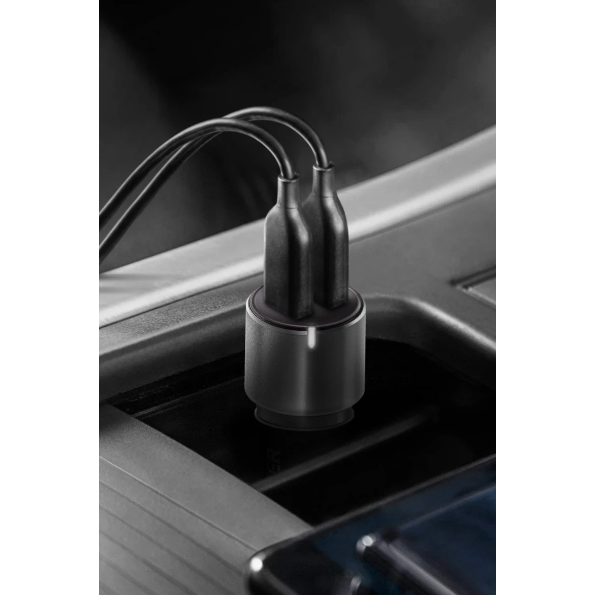 Takılı kabloları olan siyah çift USB araç şarj adaptörü.