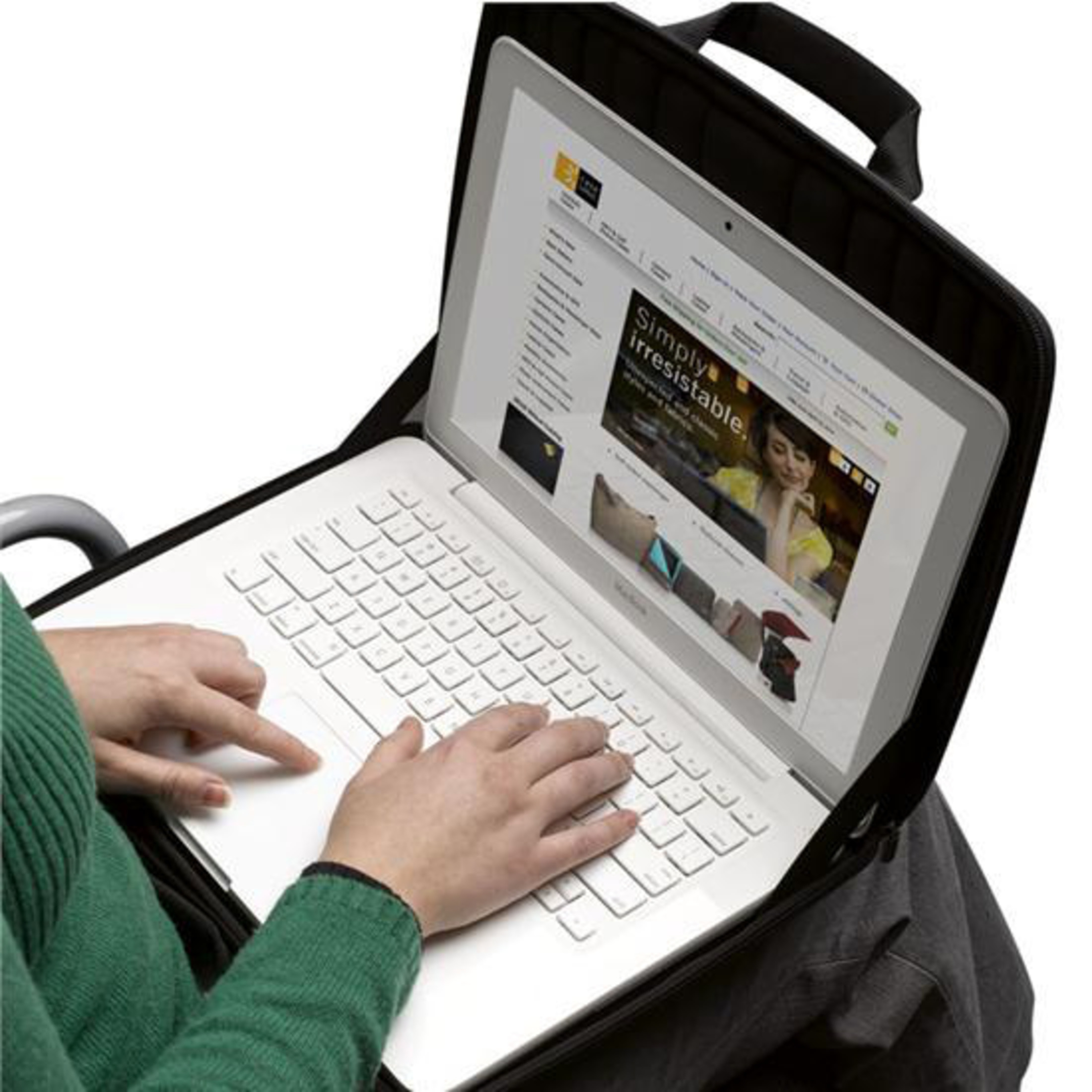 Eine Person tippt auf einem weißen Laptop, der in einer schwarzen Tasche steht.