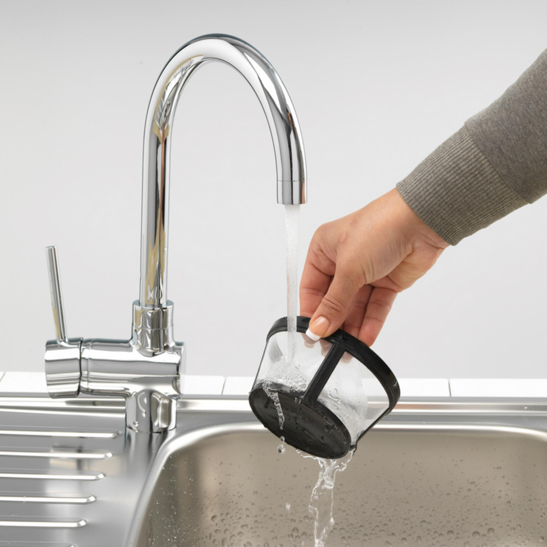 Filtr jest płukany pod bieżącą wodą w zlewie.