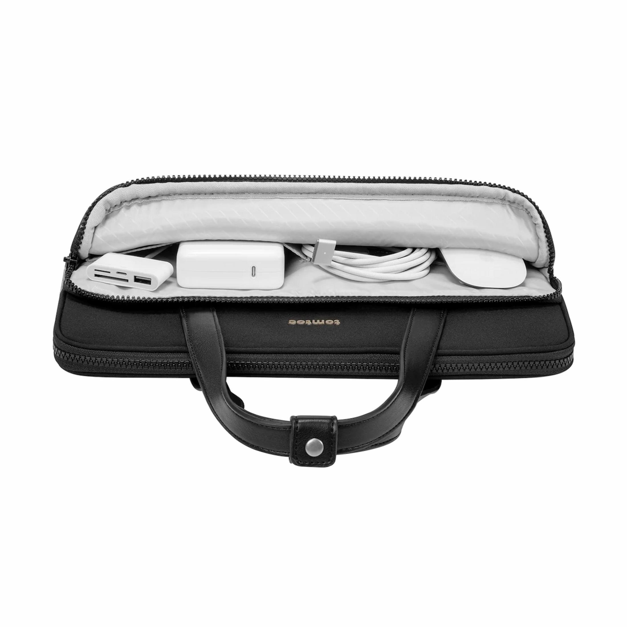 Borsa nera per laptop con manici, aperta, mostra caricatore, cavo, mouse e adattatore.