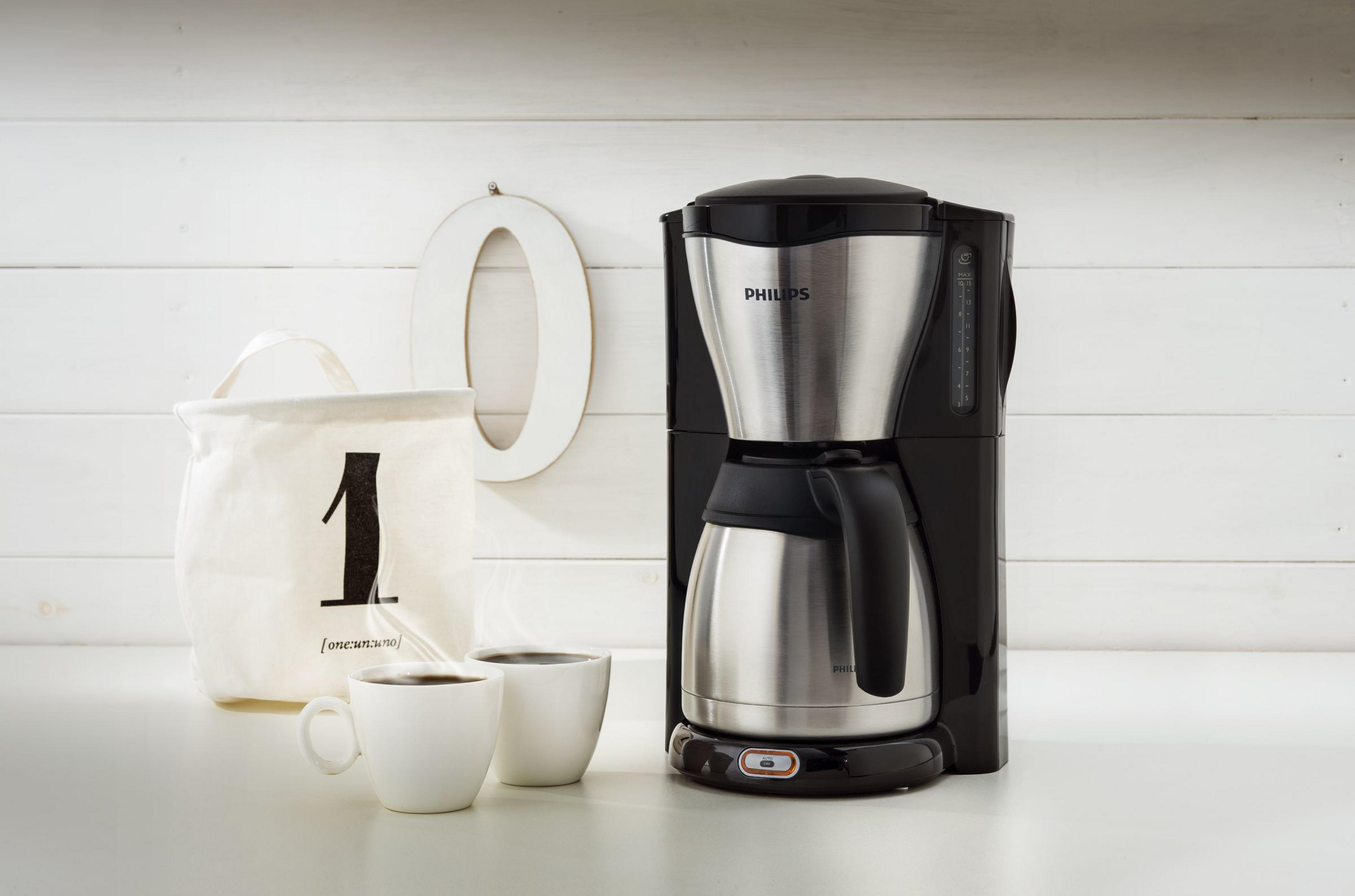 Una caffettiera Philips con caraffa termica, due tazze e una borsa con il numero 1.