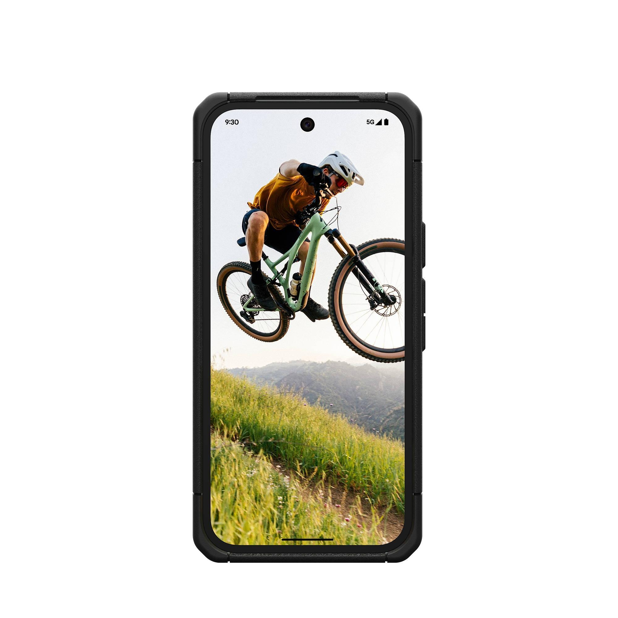 Mountainbiker springt über einen Hügel mit grünem Fahrrad und gelbem Trikot.