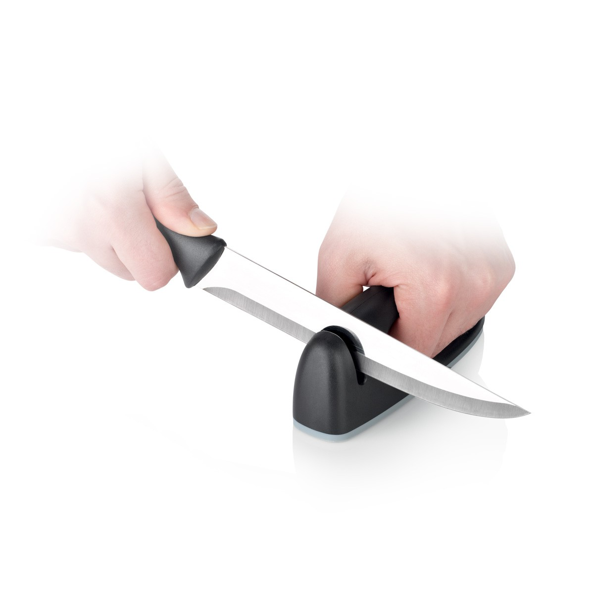 Hände schärfen ein Messer auf einem schwarzen Schärfer vor weißem Hintergrund.