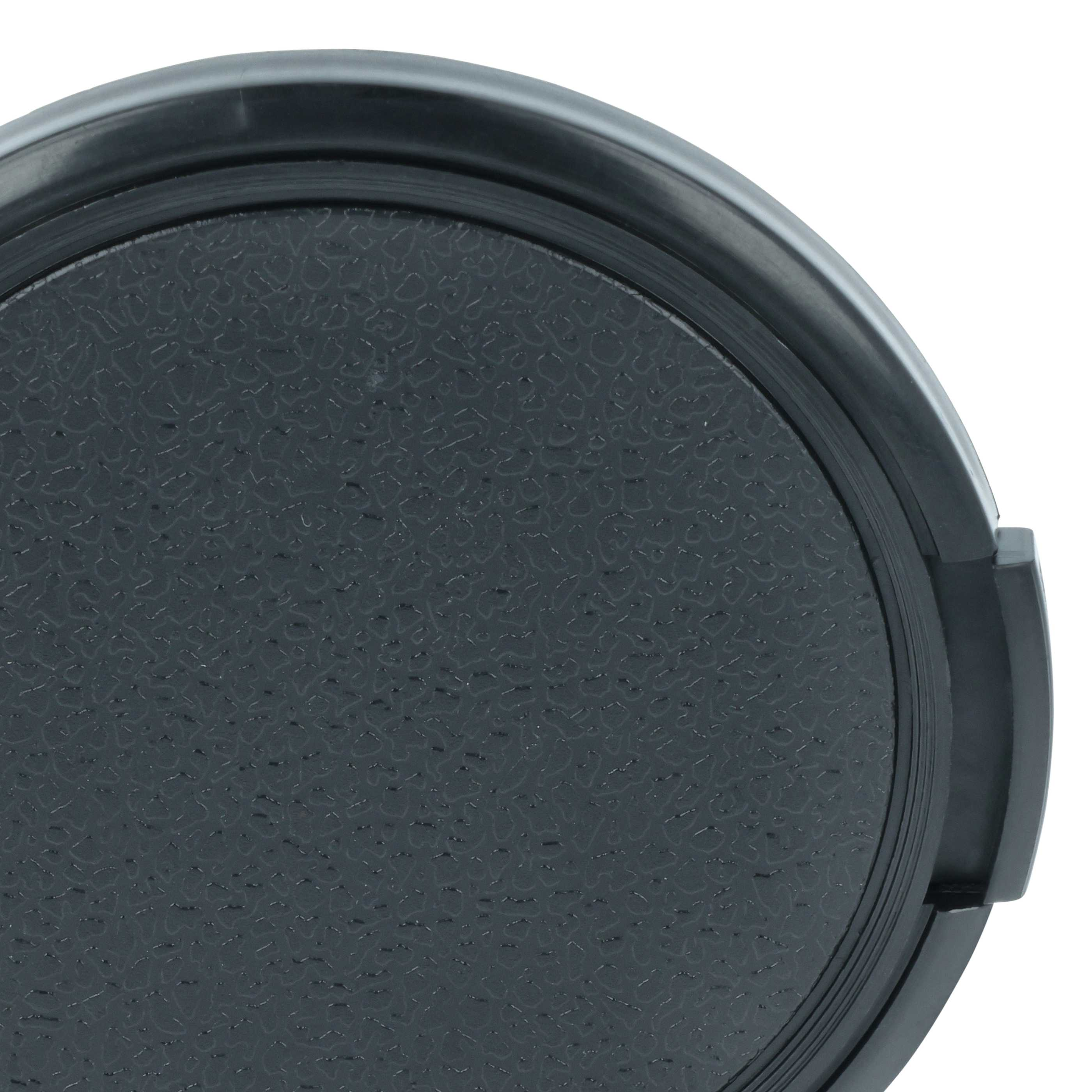 Eine schwarze Objektivkappe mit texturierter Oberfläche und einem Rand.