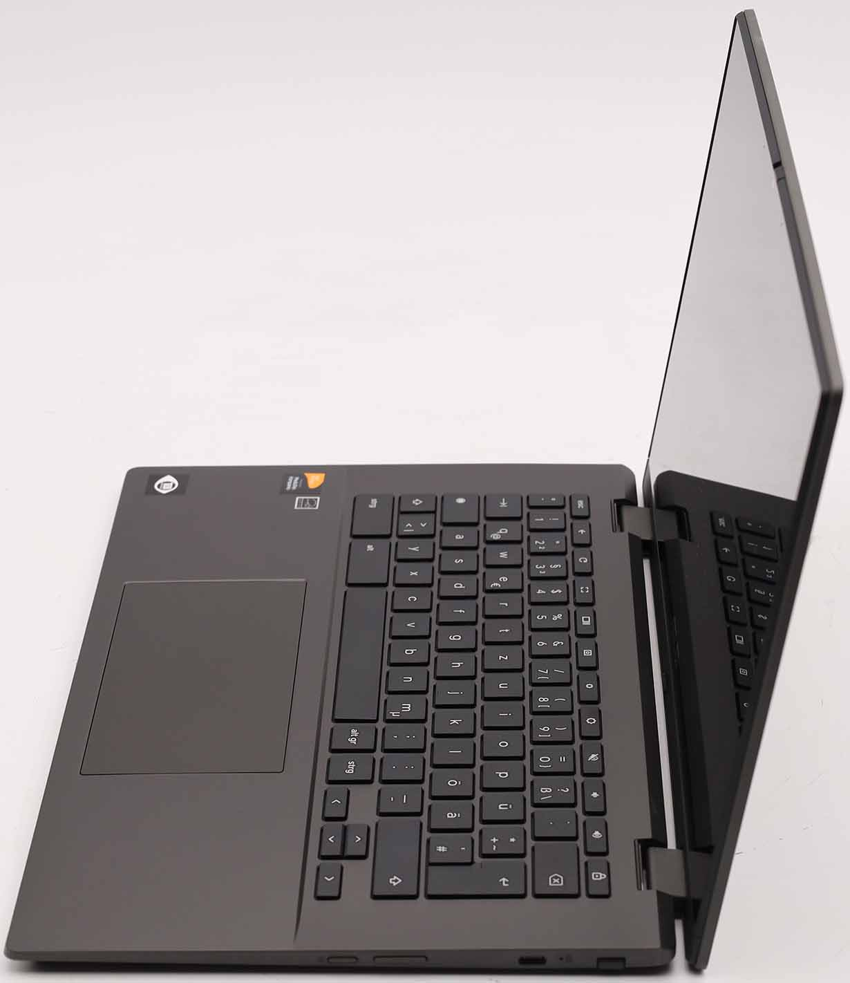 Ein dunkler Laptop mit geöffnetem Bildschirm und Tastatur auf weißem Hintergrund.