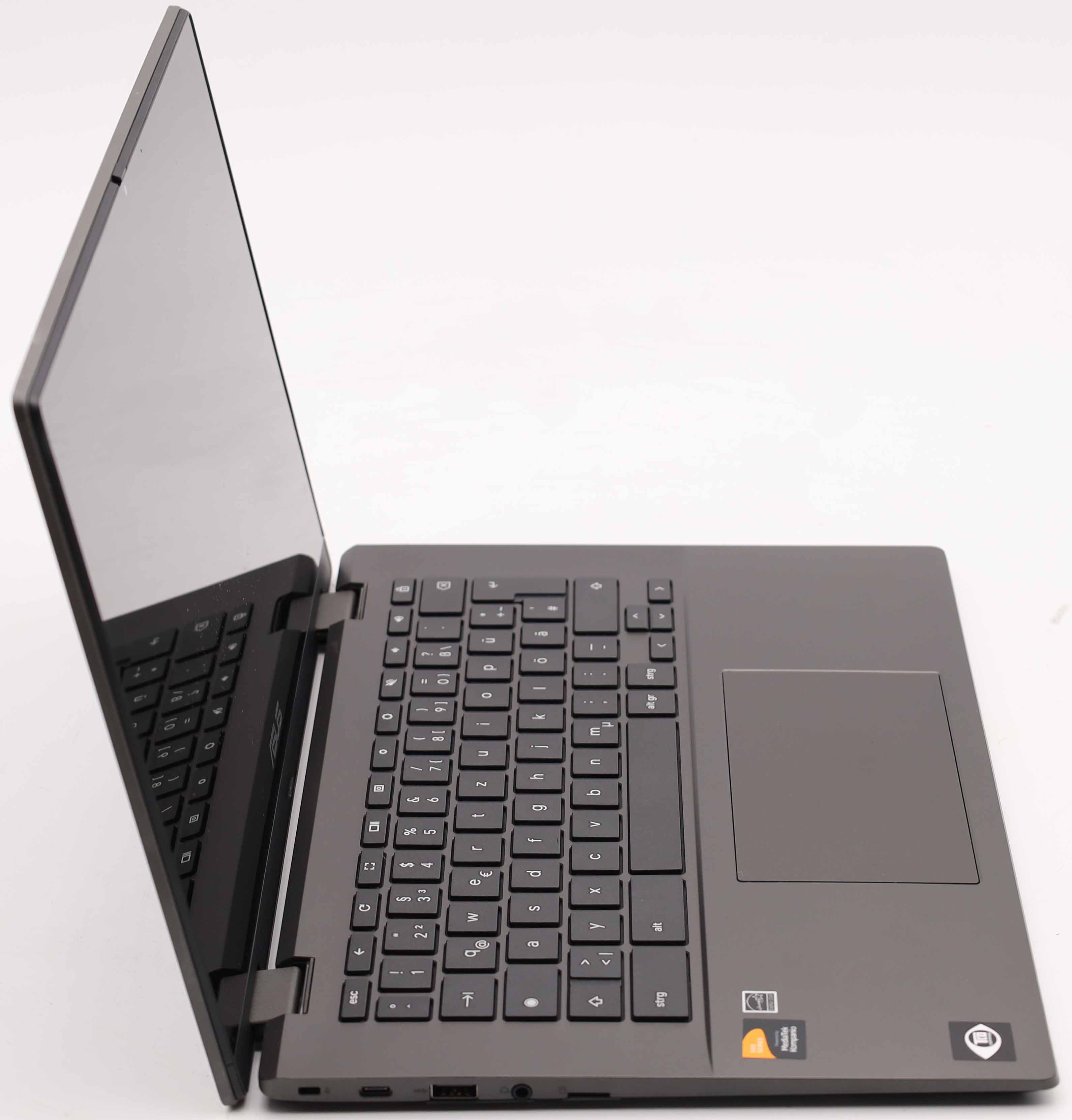 Ein dunkler Laptop ist geöffnet und steht auf einer weißen Oberfläche.