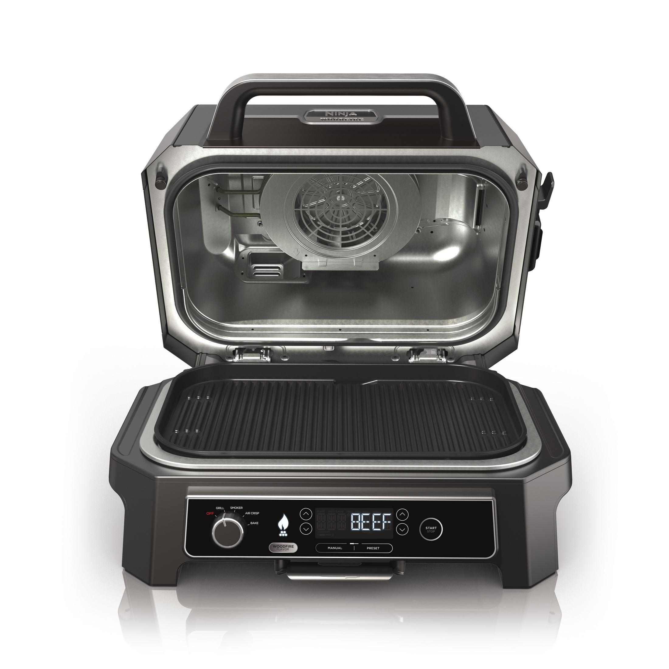 Een open zwarte Ninja Woodfire grill met een zilveren interieur en bedieningspaneel.
