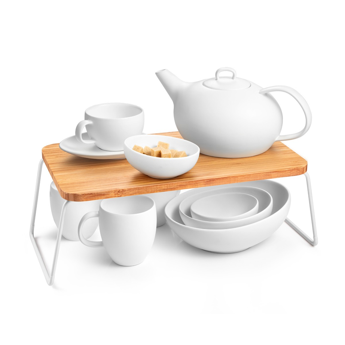 Weiße Teekanne, Tasse, Schüssel mit Zuckerwürfeln und Schalen auf einem Holztablett.