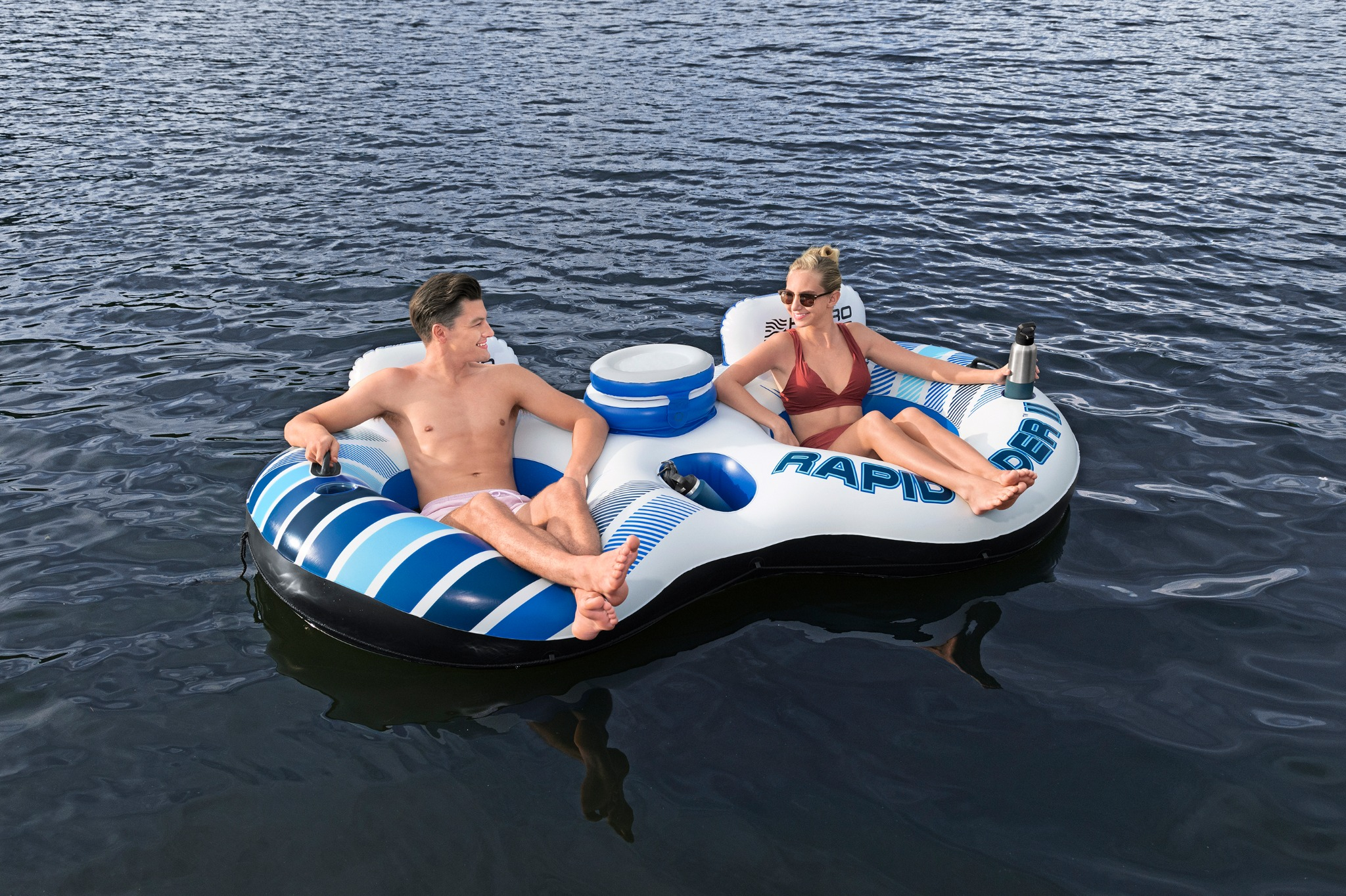 Ein Mann und eine Frau entspannen sich auf einem aufblasbaren Floß auf dem Wasser.