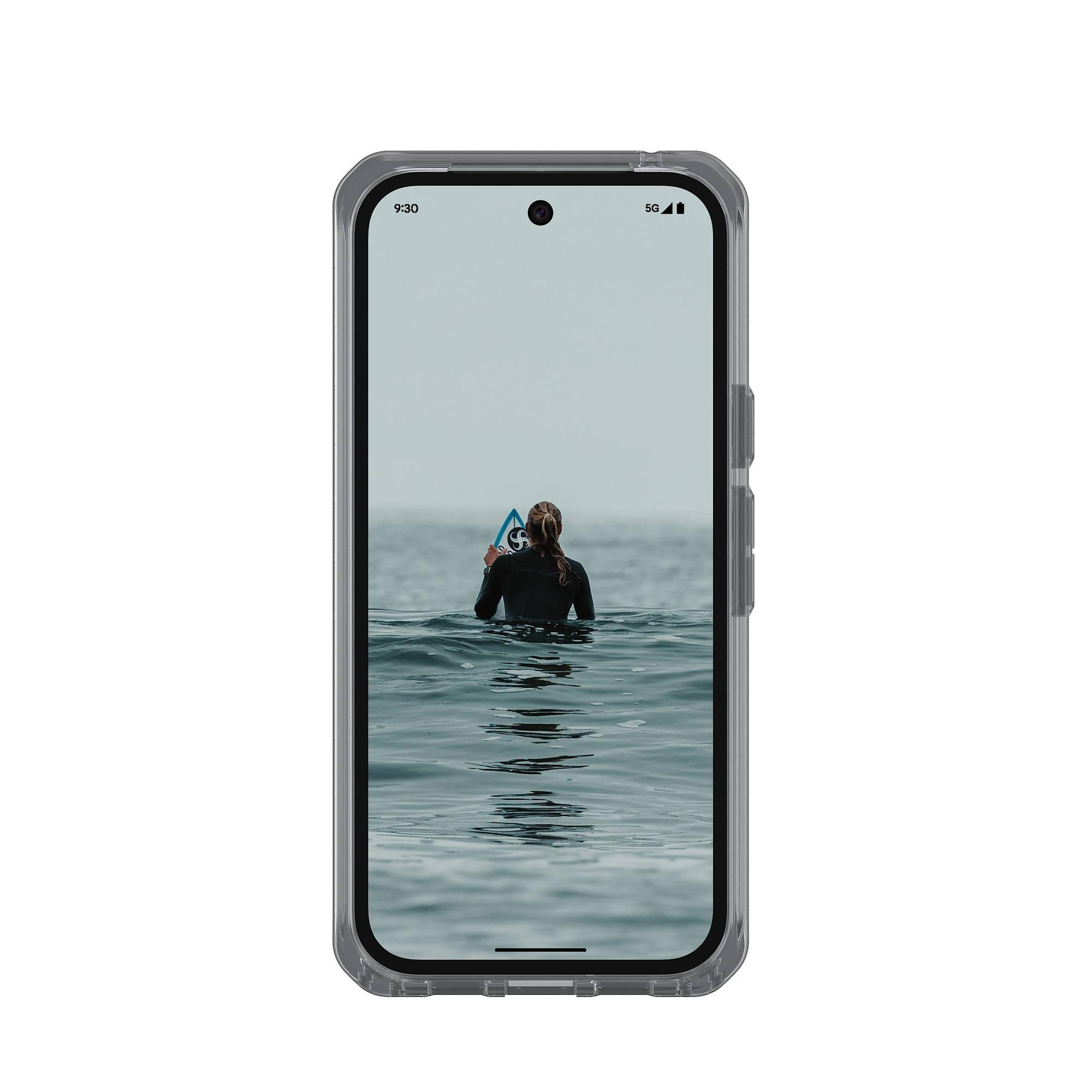 Surferin im schwarzen Neoprenanzug mit Surfbrett im Wasser.