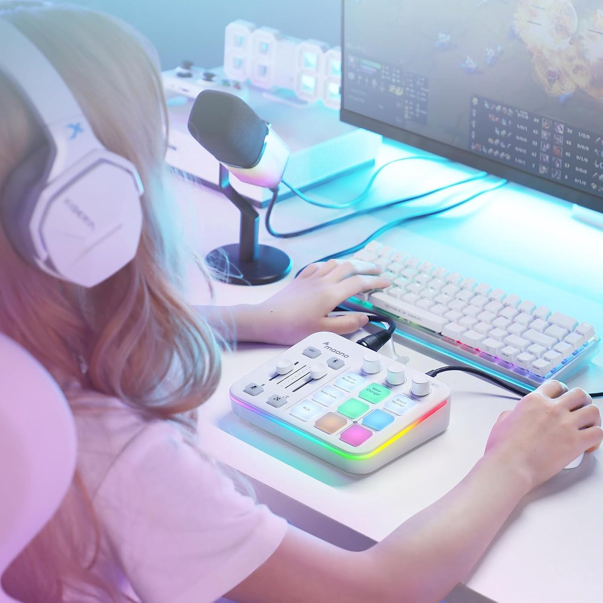 A person with headphones uses a colorful audio mixer and keyboard, gaming setup.