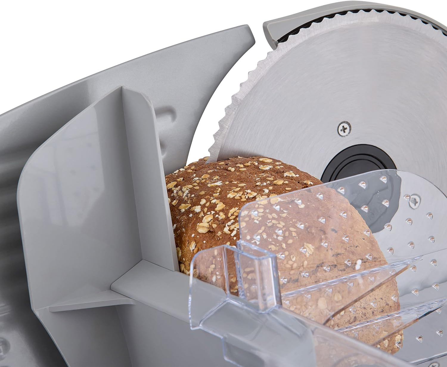 Krajacz do chleba z okrągłym, ząbkowanym ostrzem kroi bochenek chleba.