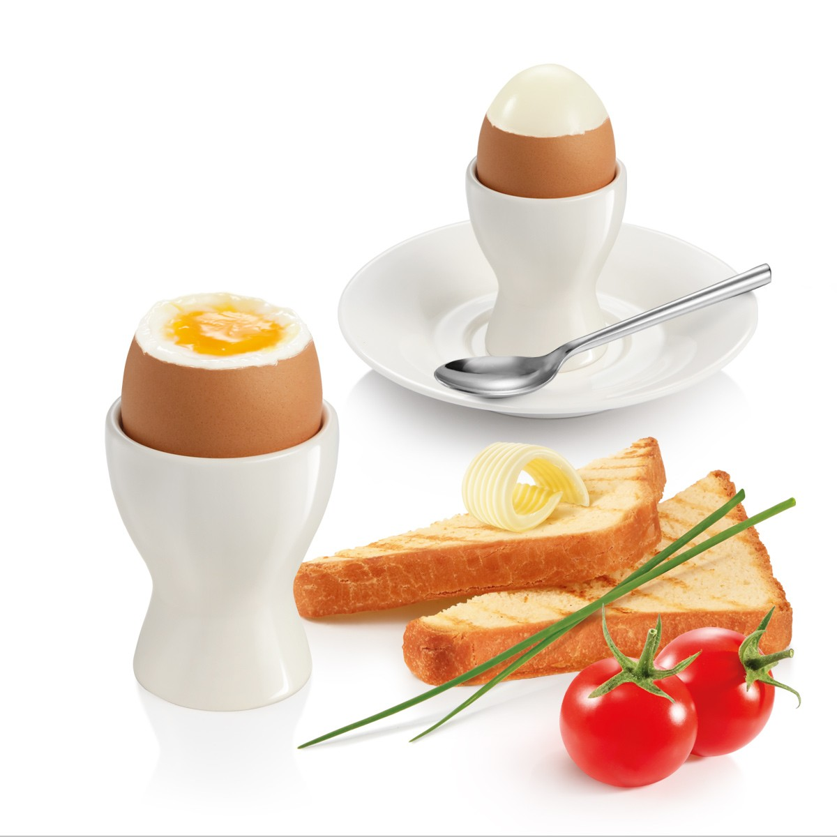 Zwei weichgekochte Eier in Haltern, Toast, Schnittlauch und Tomaten.
