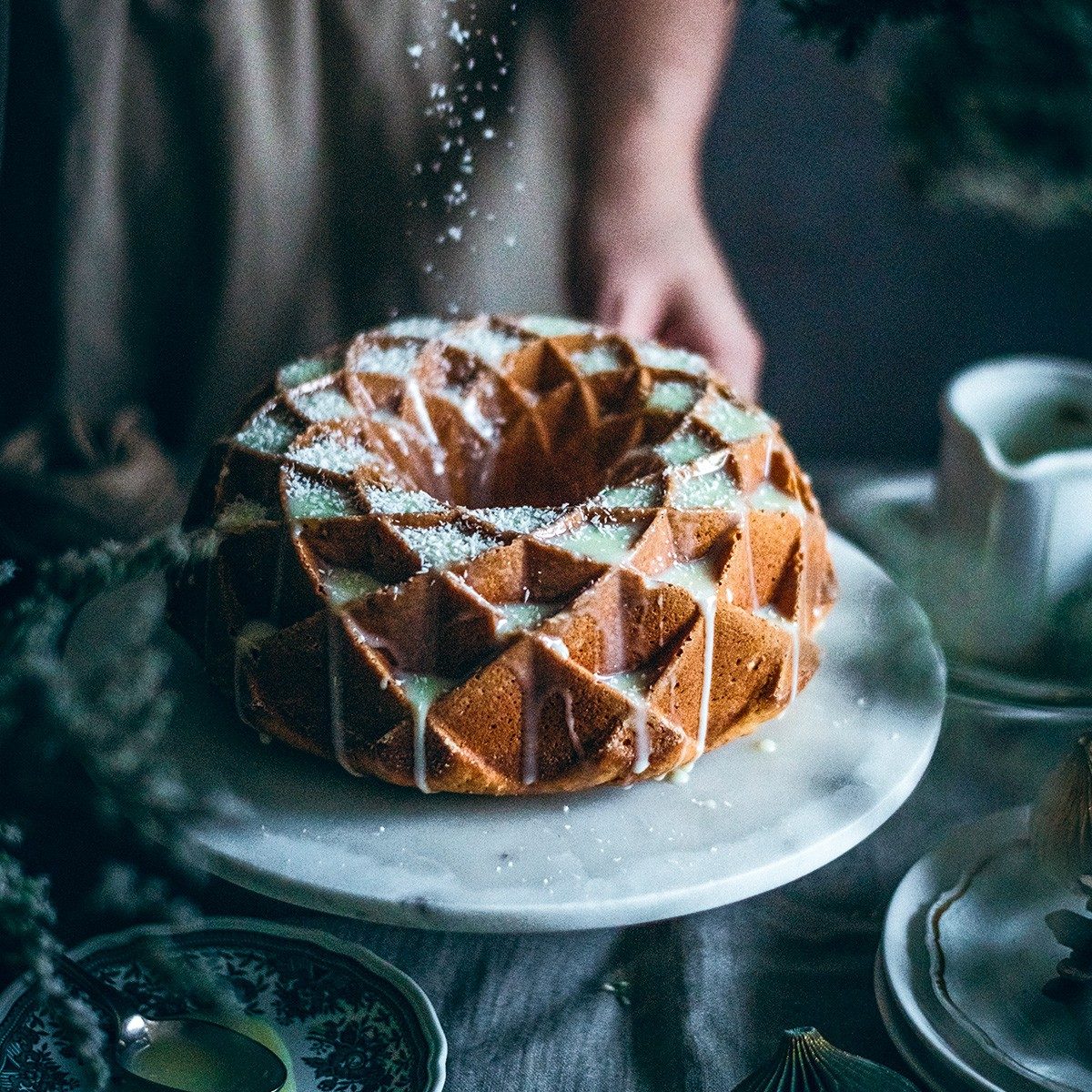 Ein Gugelhupf mit Zuckerguss und Kokosraspeln wird bestreut.