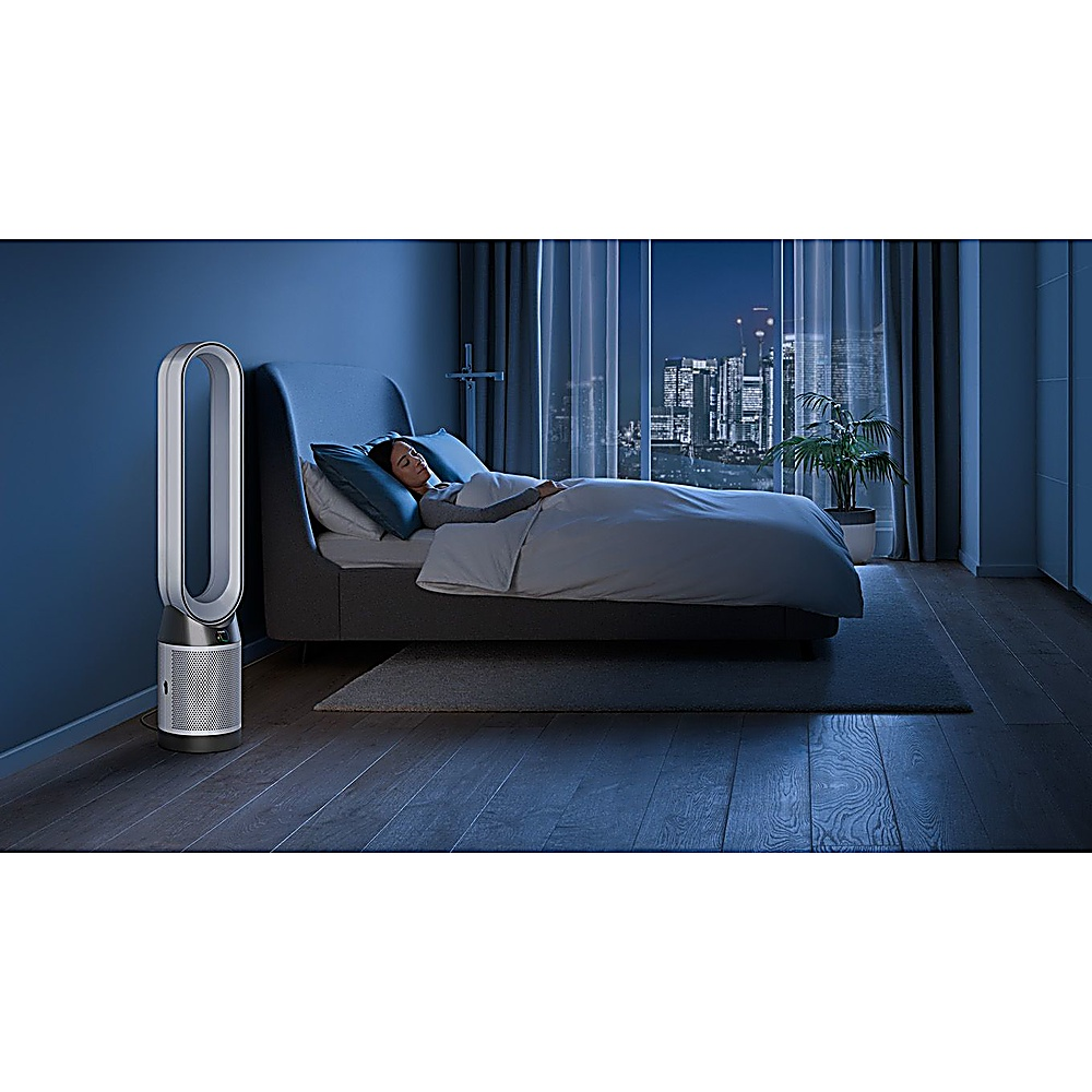Una donna dorme a letto, un purificatore d'aria accanto, città di notte.