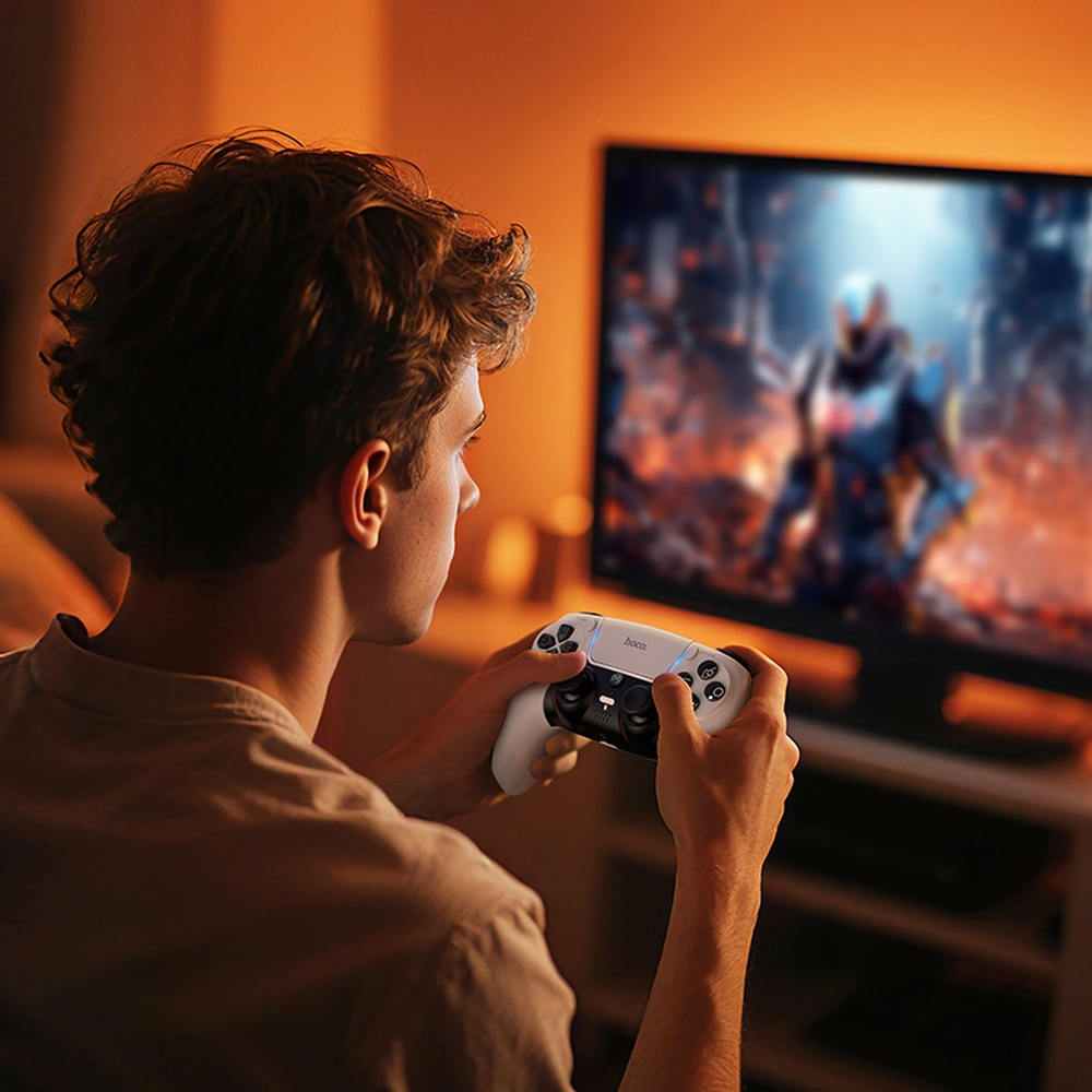 Un hombre juega videojuegos con un mando blanco frente a un televisor.