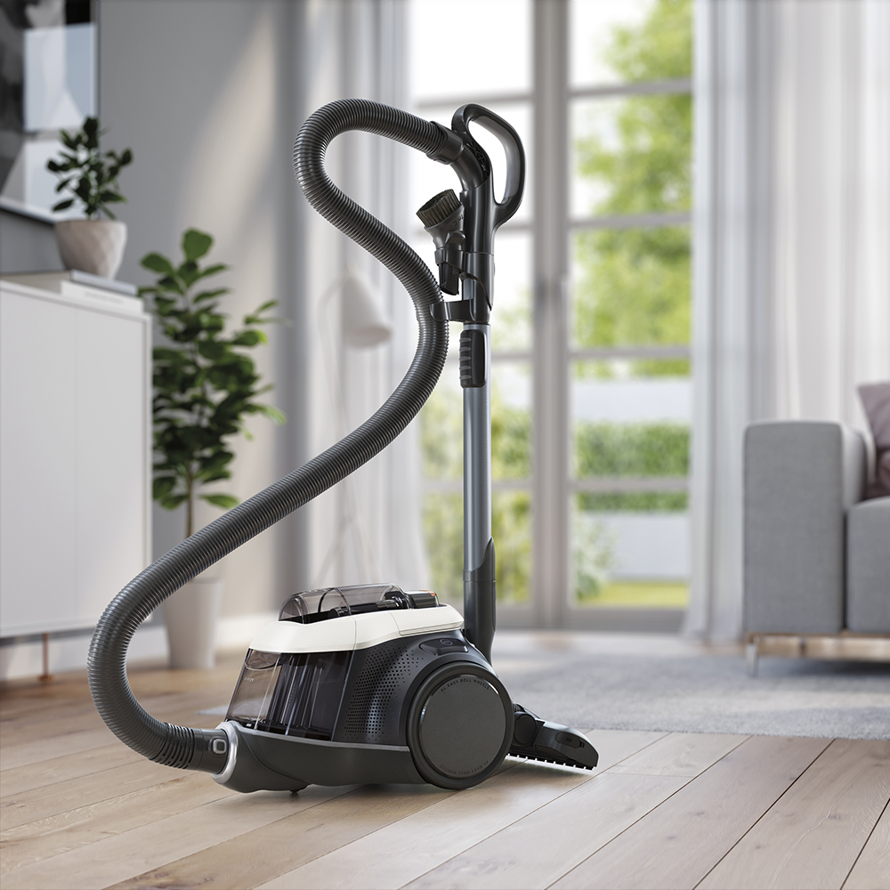 Nowoczesny odkurzacz z wężem stoi na drewnianej podłodze.