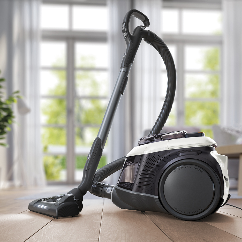 Nowoczesny odkurzacz z czarnym wężem i uchwytem na drewnianej podłodze.