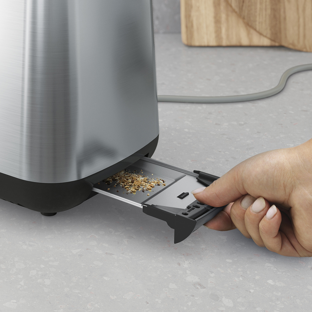 Eine Hand zieht eine Krümelschublade unter einem Toaster heraus.