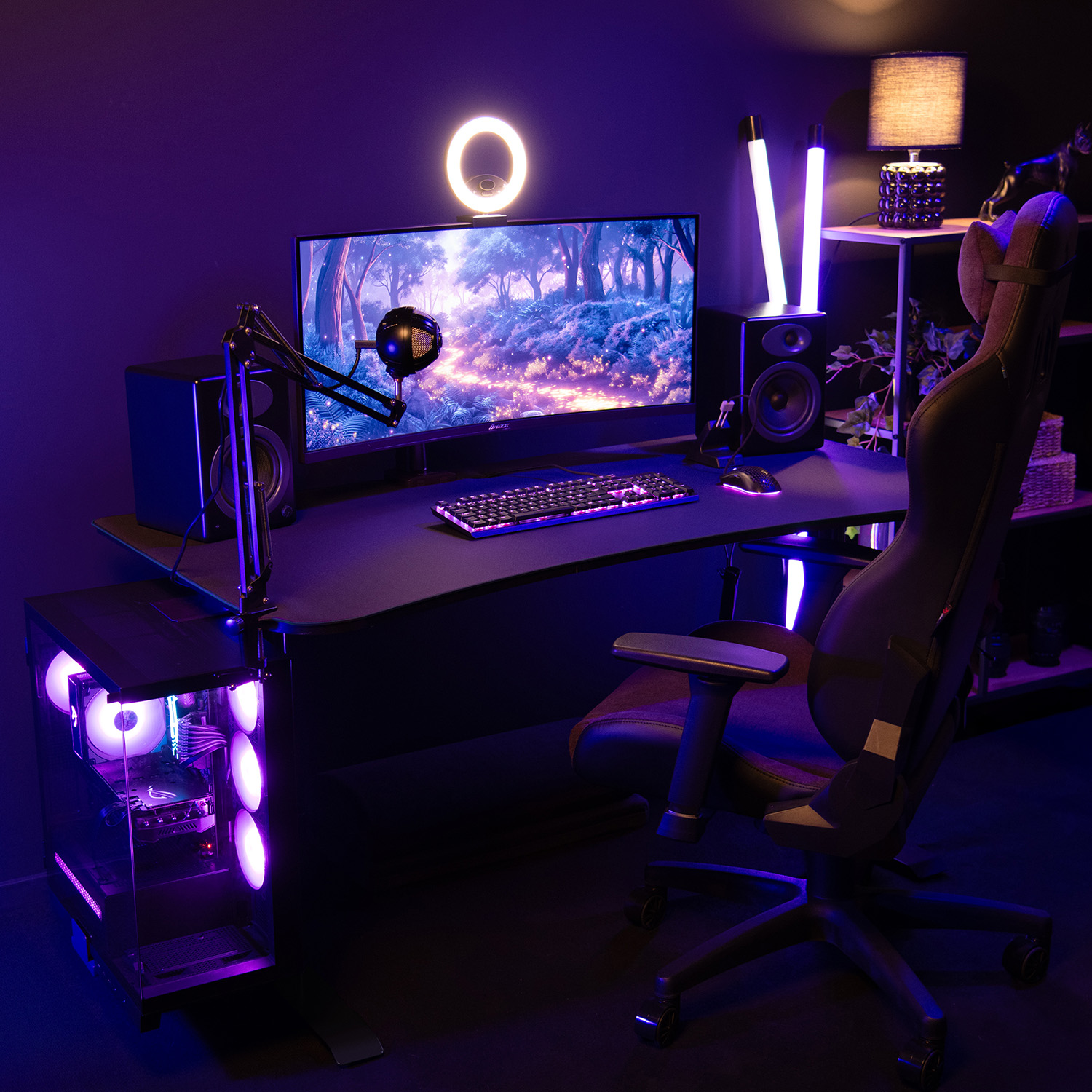 Gaming setup met verlichte pc, microfoon, breed scherm en stoel.