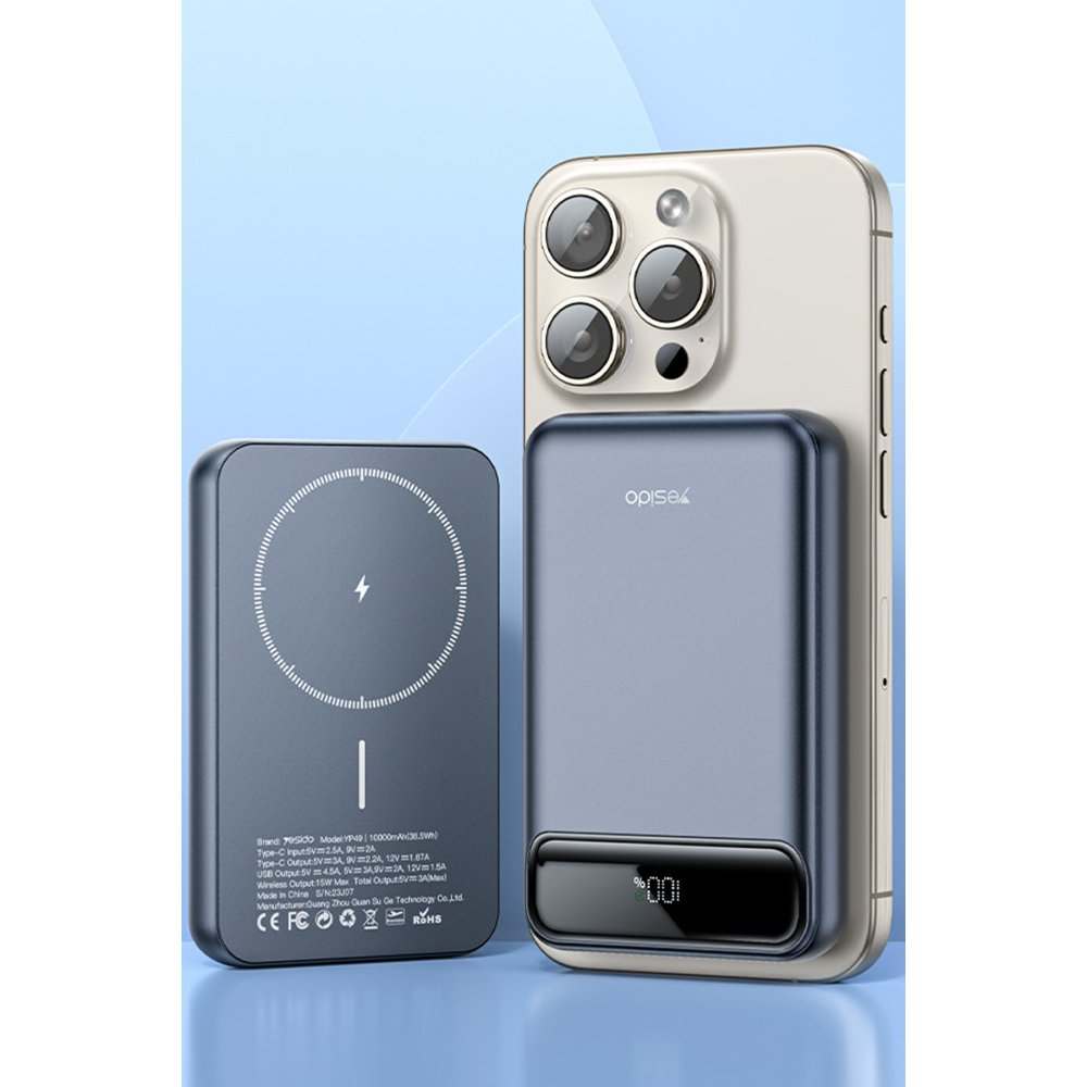 Dairesel tasarımlı gri powerbank bir cep telefonunun yanında duruyor.