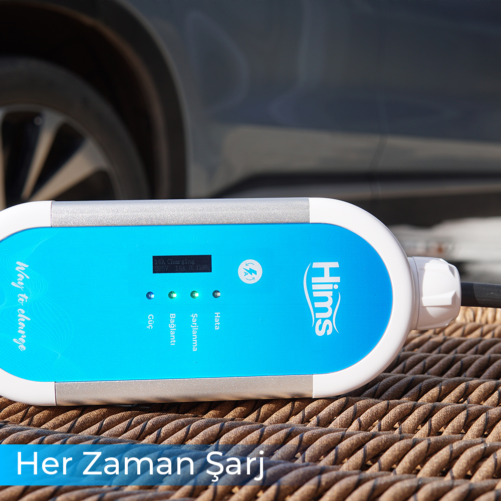 Ekranlı mavi elektrikli araç şarj cihazı şarj verilerini gösteriyor. Bir arabanın bir kısmı görünüyor.