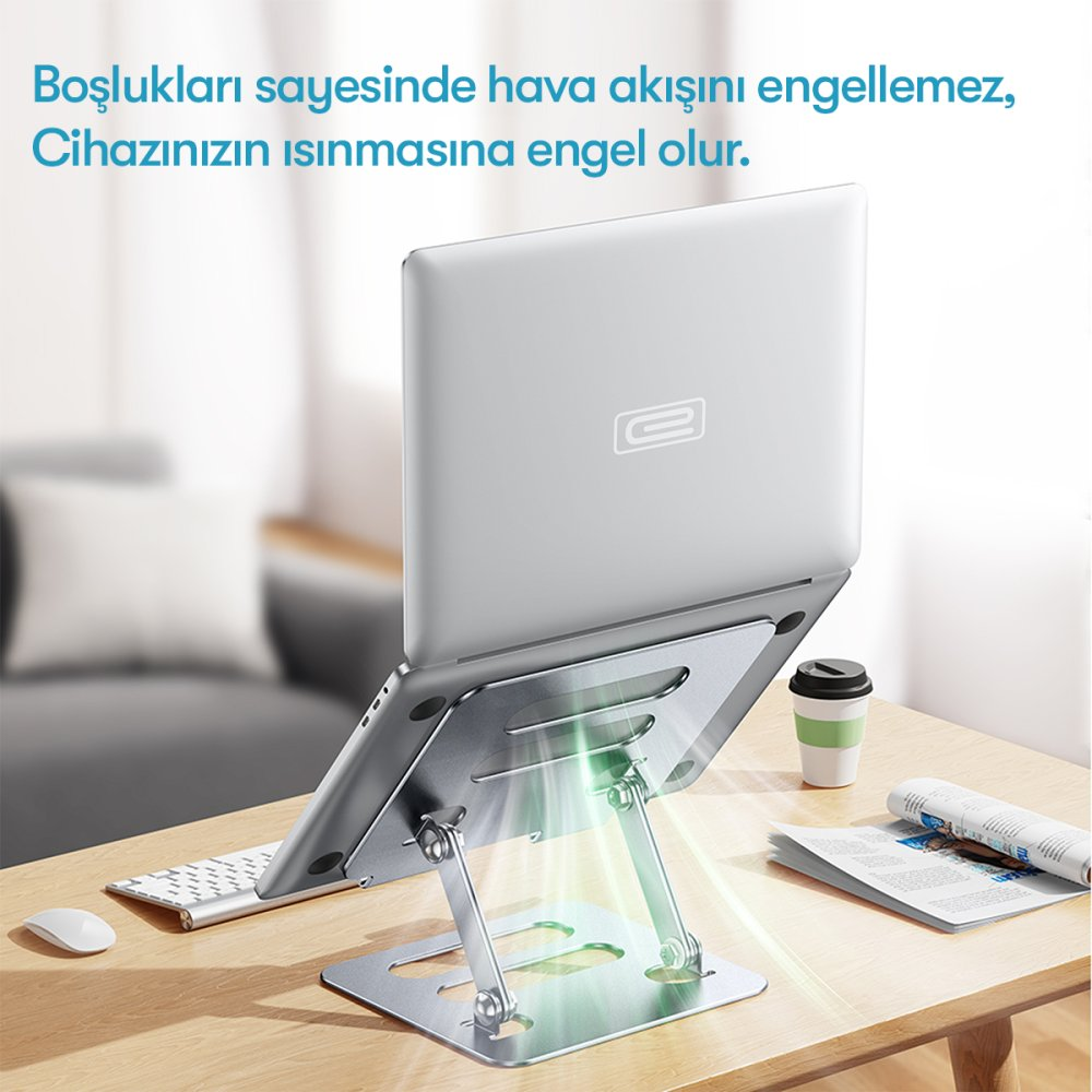 Gümüş renkli bir dizüstü bilgisayar, hava akışına izin veren bir stantta duruyor.