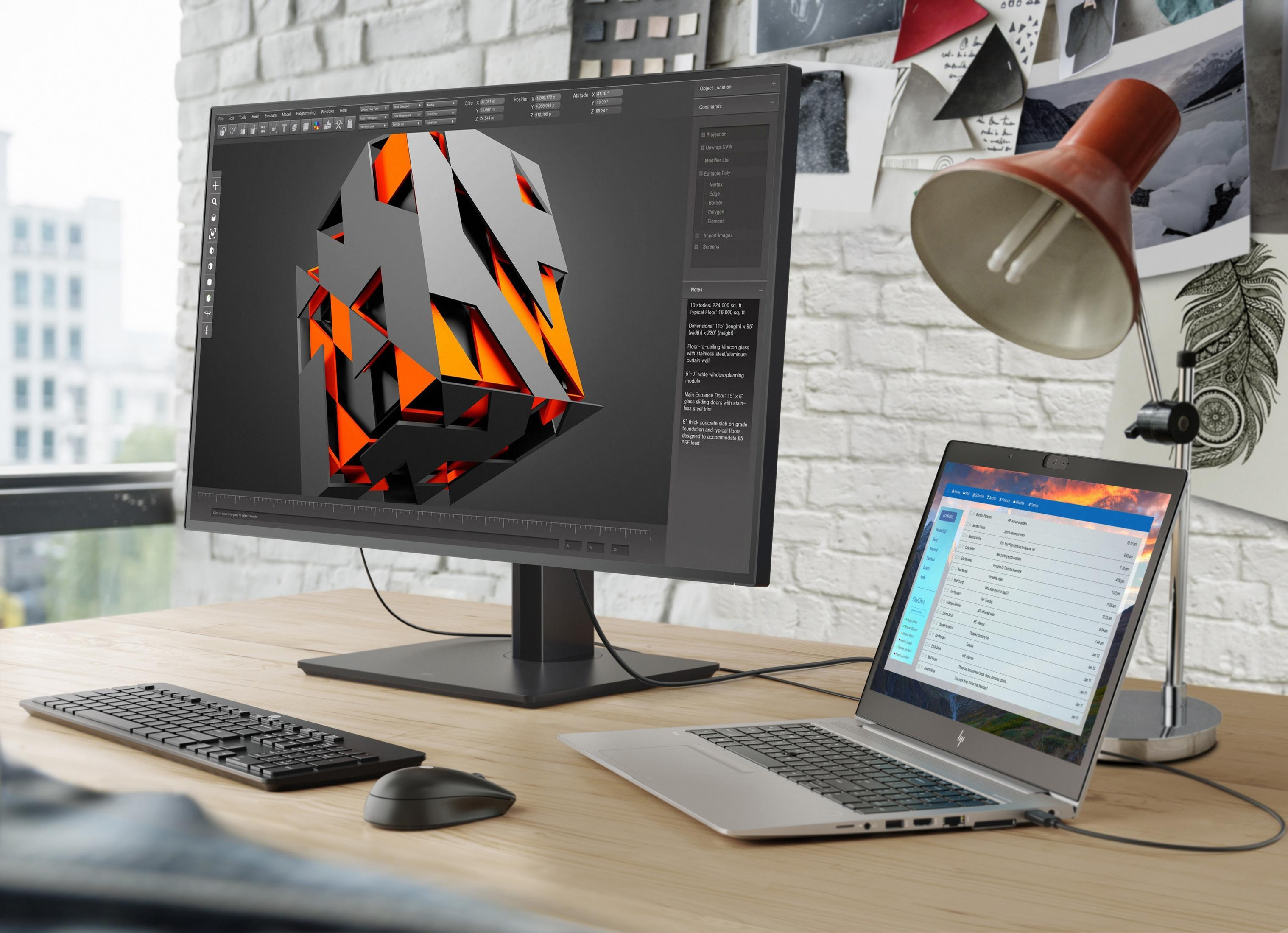Un escritorio con un monitor grande que muestra un modelo 3D y un portátil.