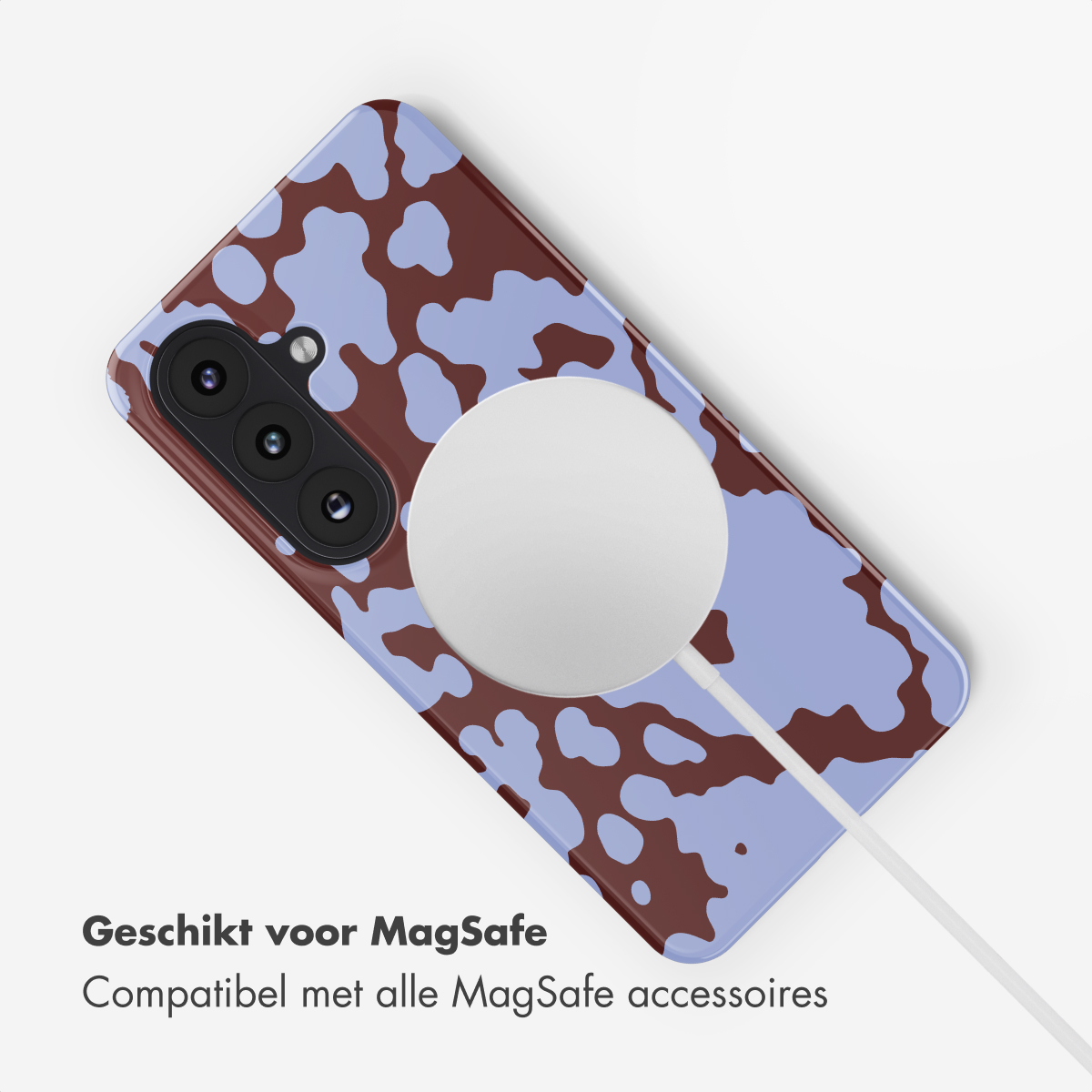 Een telefoonhoesje met paars en bruin koeienprintpatroon, met MagSafe lader.