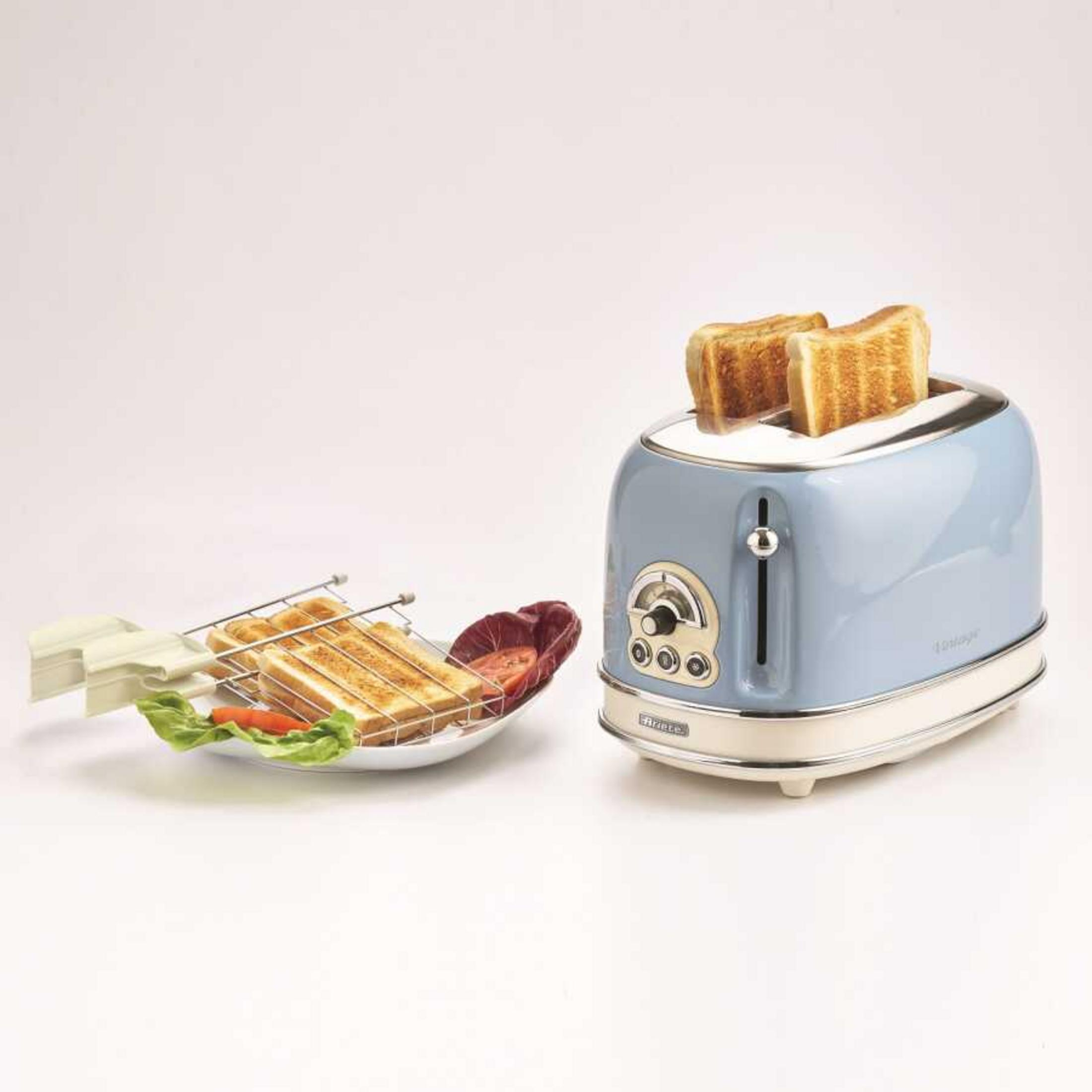 A blue retro toaster with toast and side items.