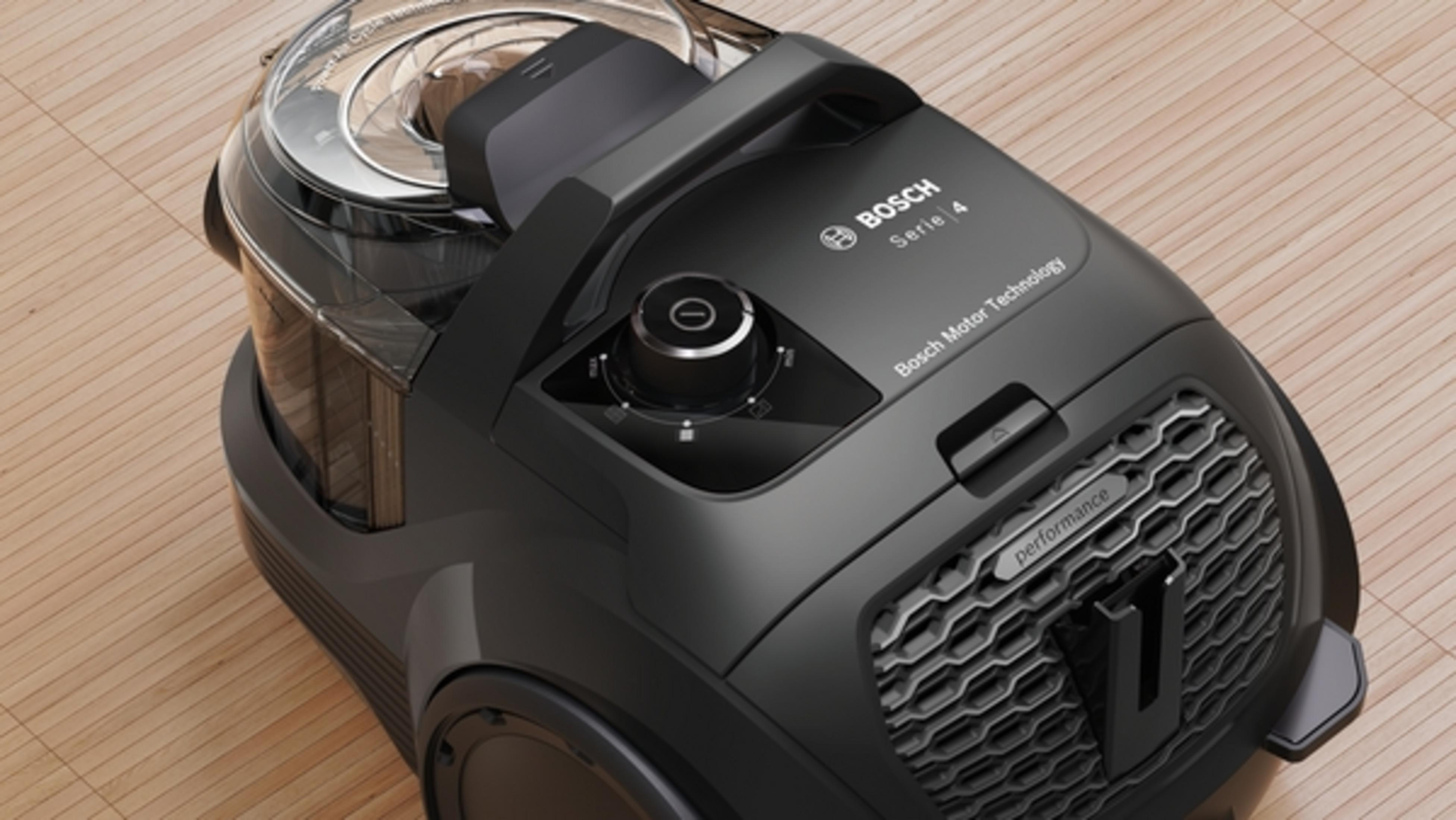 Czarny odkurzacz Bosch Serie 4 z przezroczystym pojemnikiem na drewnianej podłodze.