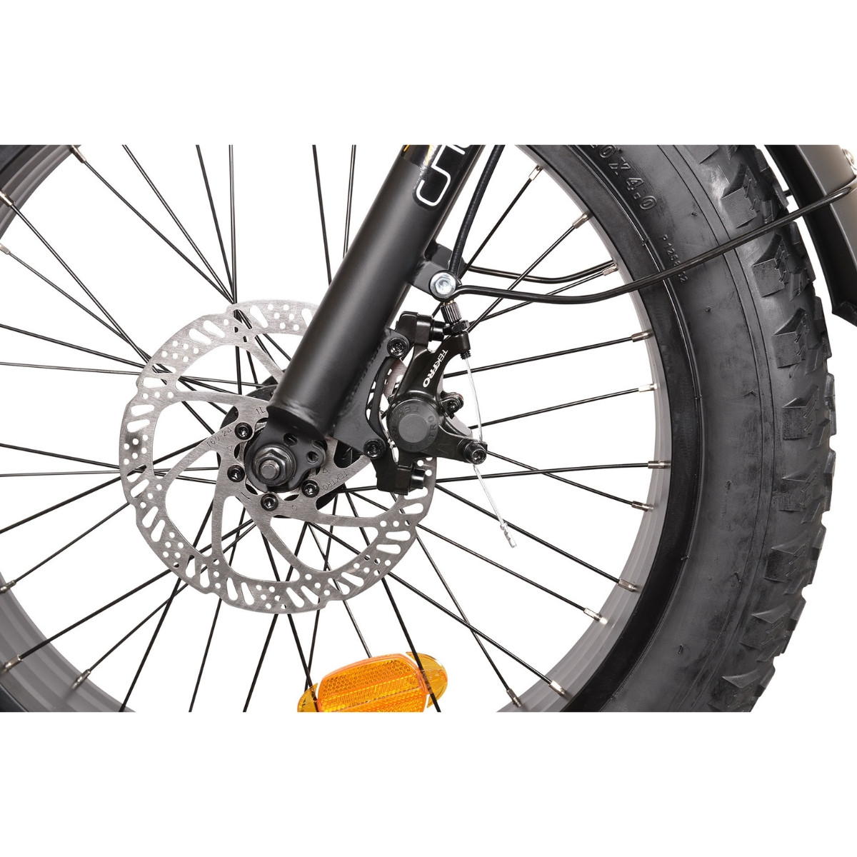 Zbliżenie przedniego koła roweru z hamulcem tarczowym, czarnym widelcem i szeroką oponą.