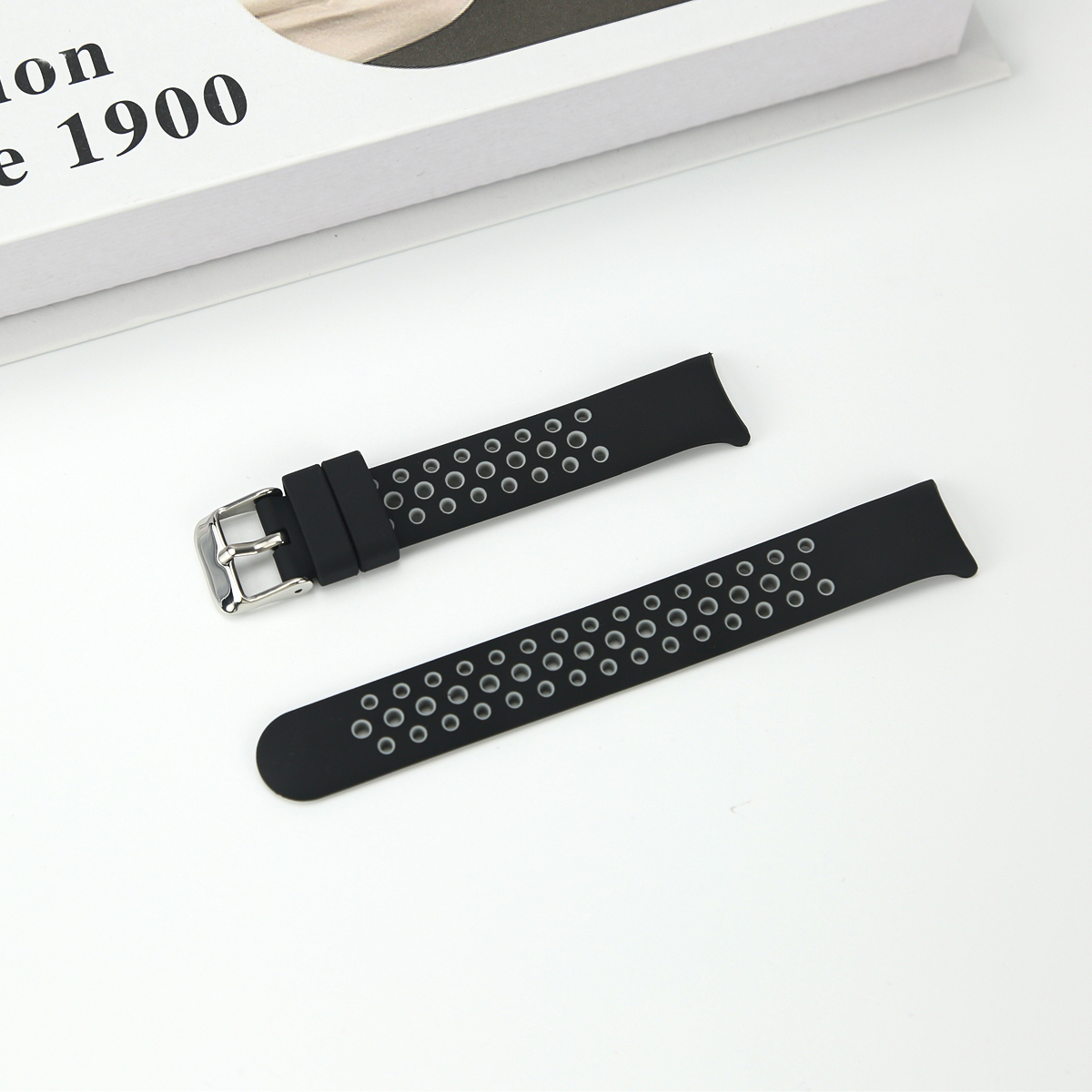 Zwei schwarze Uhrenarmbänder mit silbernen Schnallen und Lochmuster.