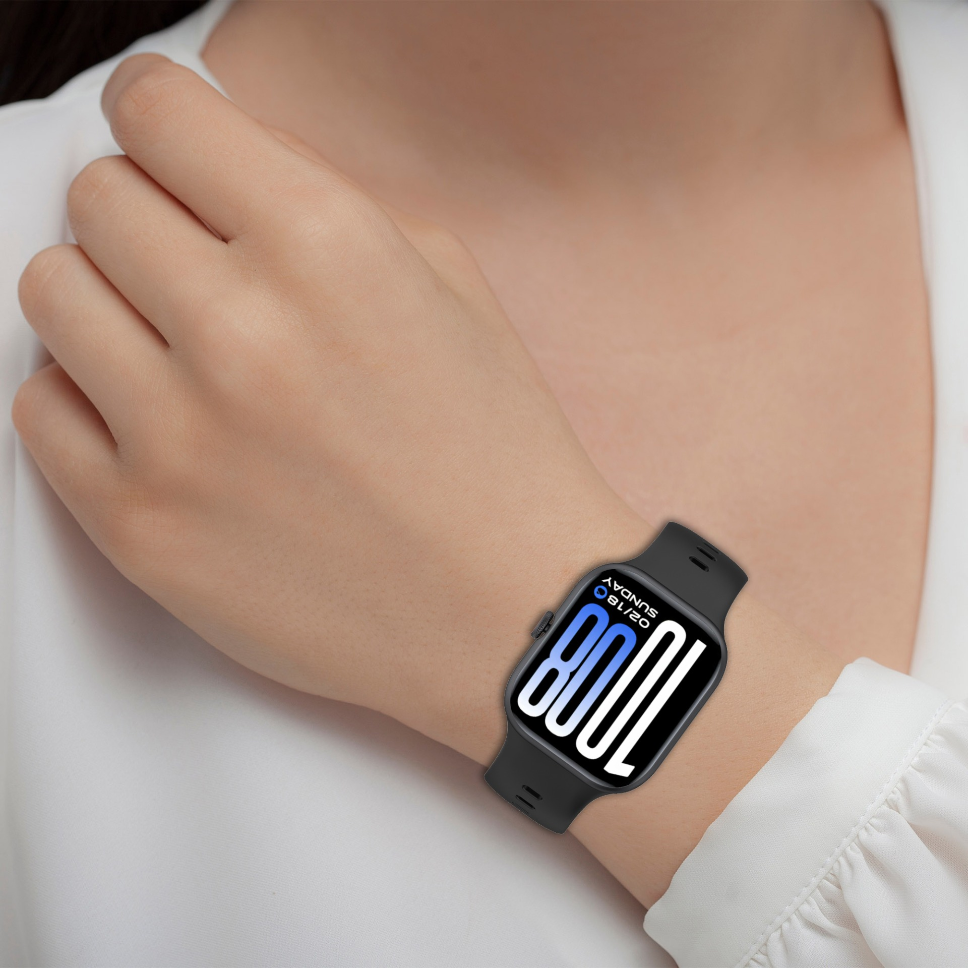 Eine Person trägt eine schwarze Smartwatch mit blau-weißer digitaler Anzeige.