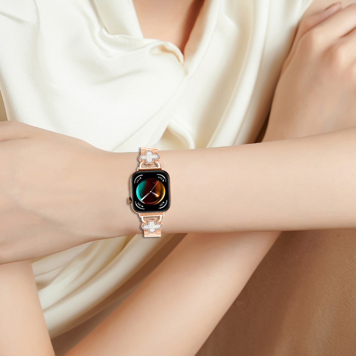 Eine Frau trägt ein roségoldenes Smartwatch mit einem Clou-Muster-Armband.