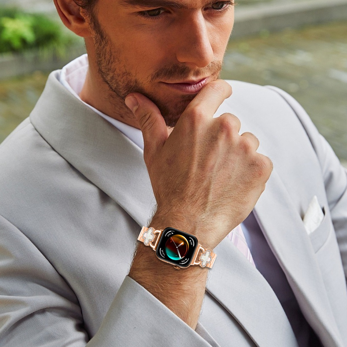 Mann mit grauem Anzug trägt eine Smartwatch mit glänzendem Armband.