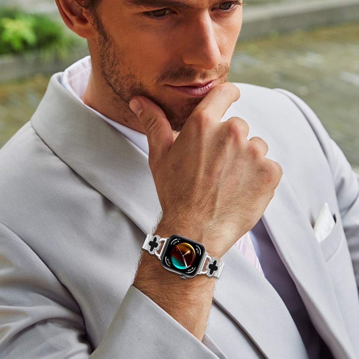Mann mit hellem Anzug und Uhr mit silbernem Armband.