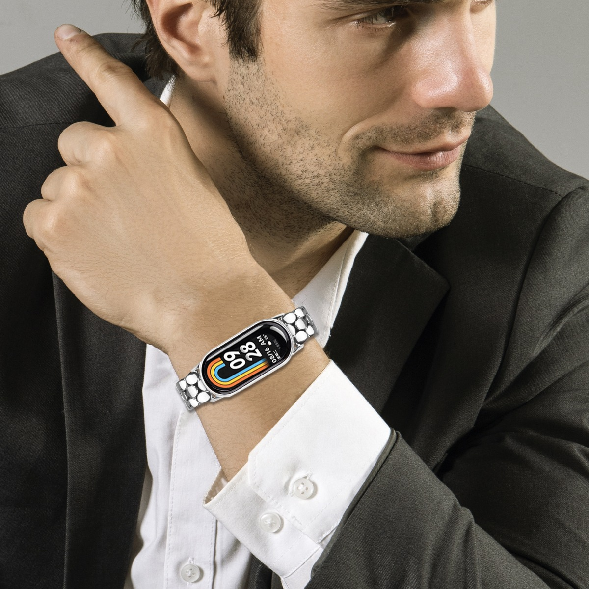 Mann trägt einen schwarzen Anzug und eine Smartwatch mit farbigem Zifferblatt.