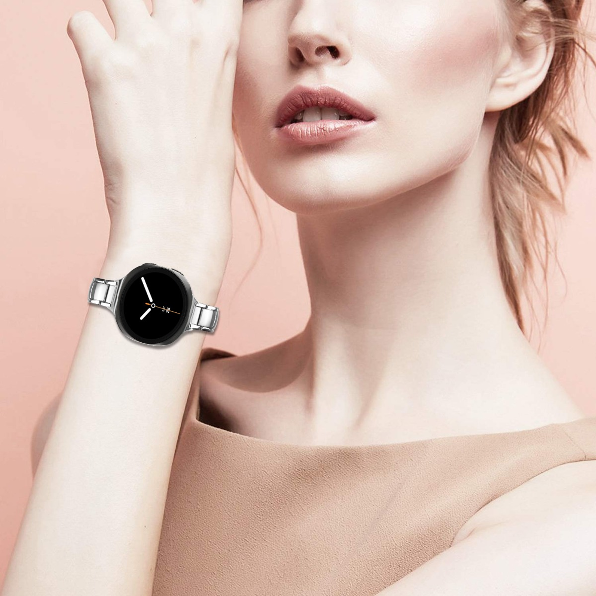 Nahaufnahme von Frauenhandgelenk mit silberner Smartwatch. Zifferblatt schwarz mit weißen Zeigern.