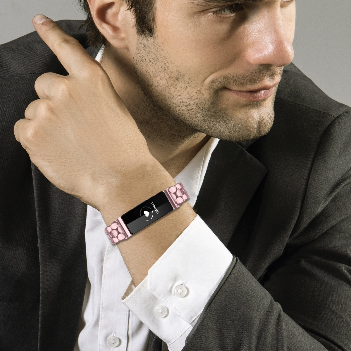 Mann trägt einen schwarzen Anzug und ein Armband mit Herzfrequenzanzeige.